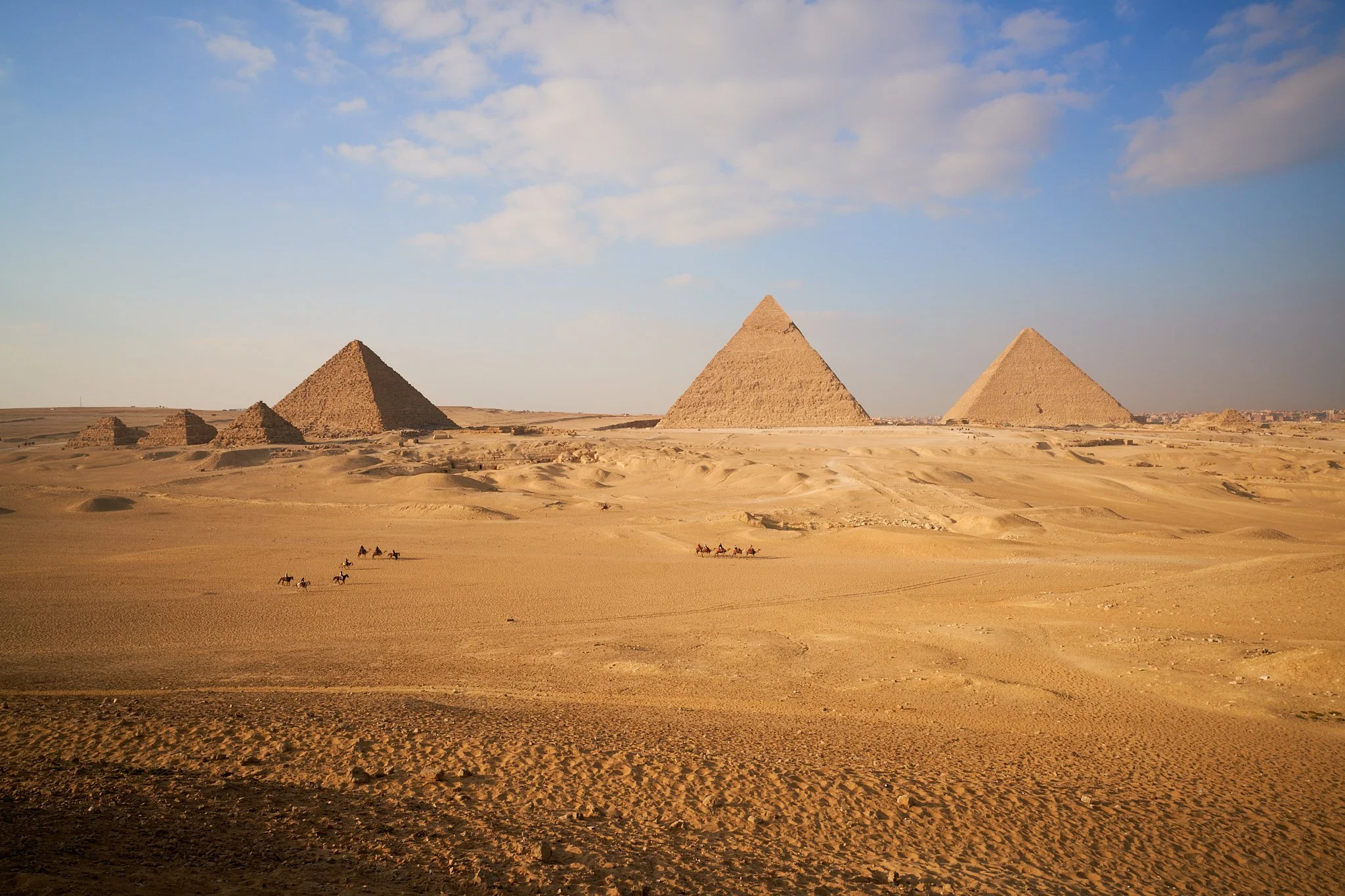 Documentary footage of camels crossing in front of the Great Pyramids of Egypt during filming for the 7X Project
