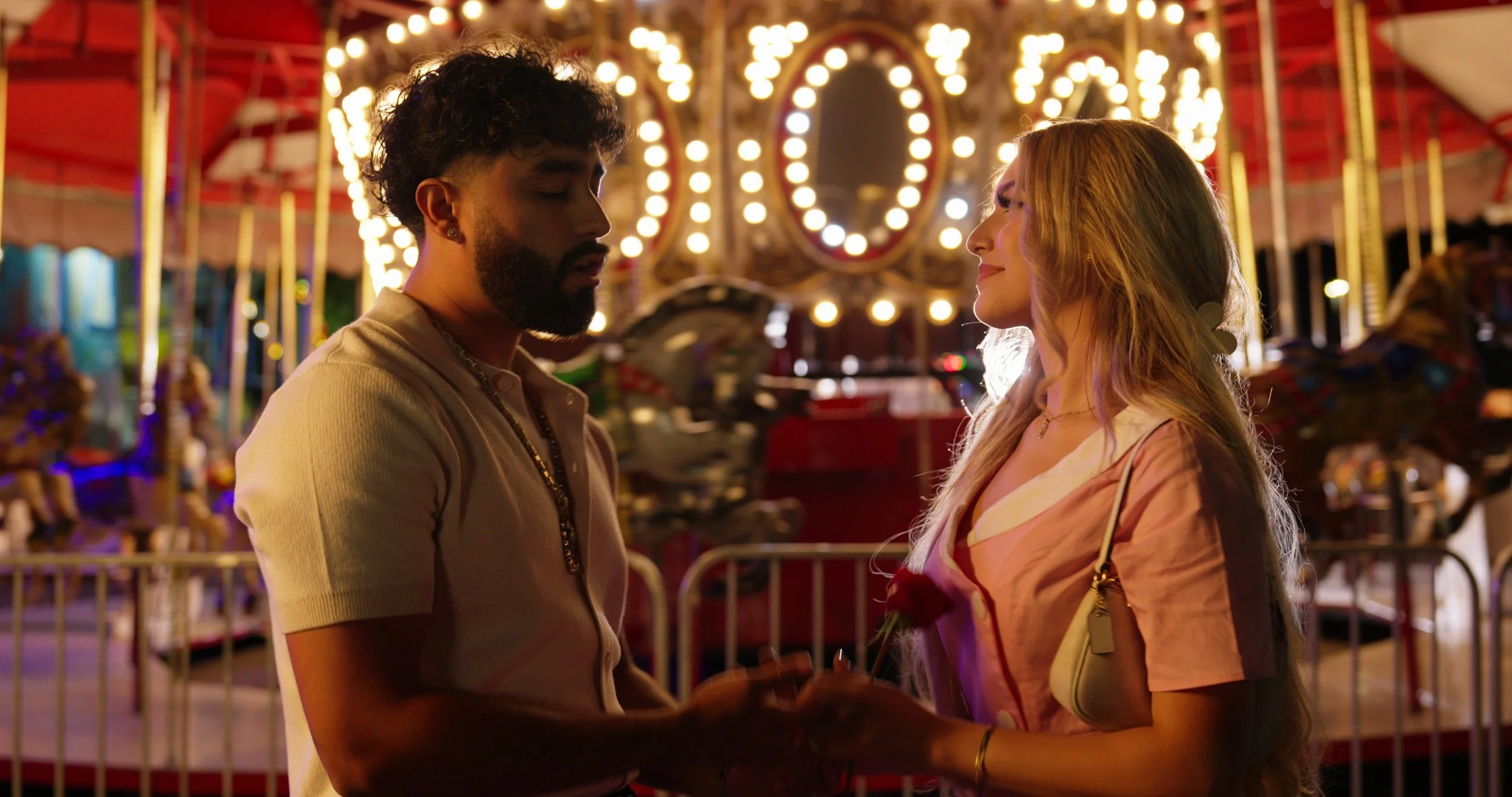 couple holding hands at fair grounds