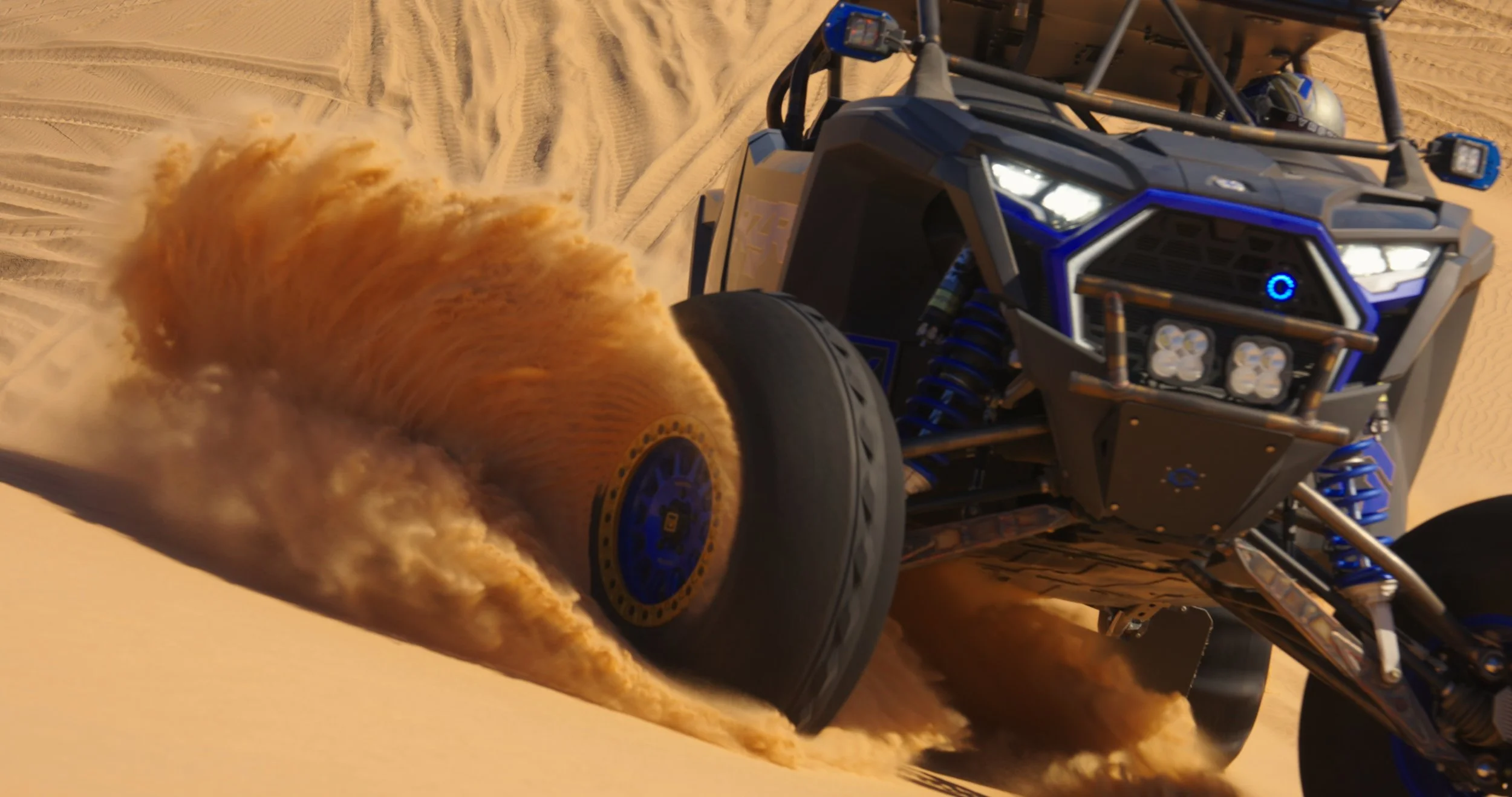 Off-road UTV kicking up sand while driving through desert dunes during an adventure guys trip.