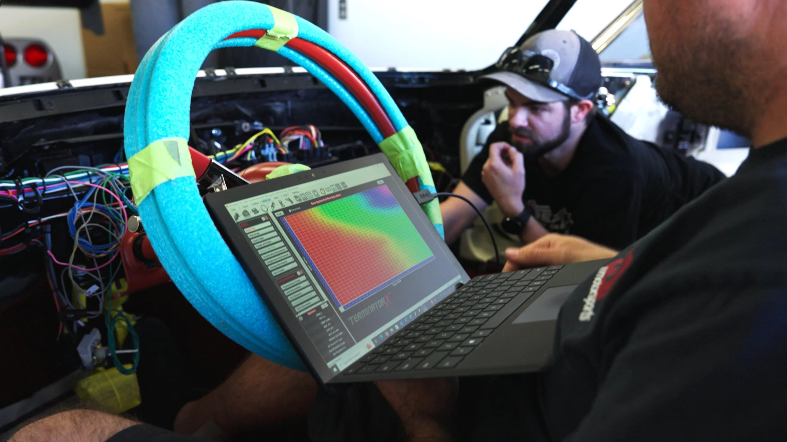 Streamline performance technician tuning engine calibration using laptop diagnostics during Barrett-Jackson Cup build