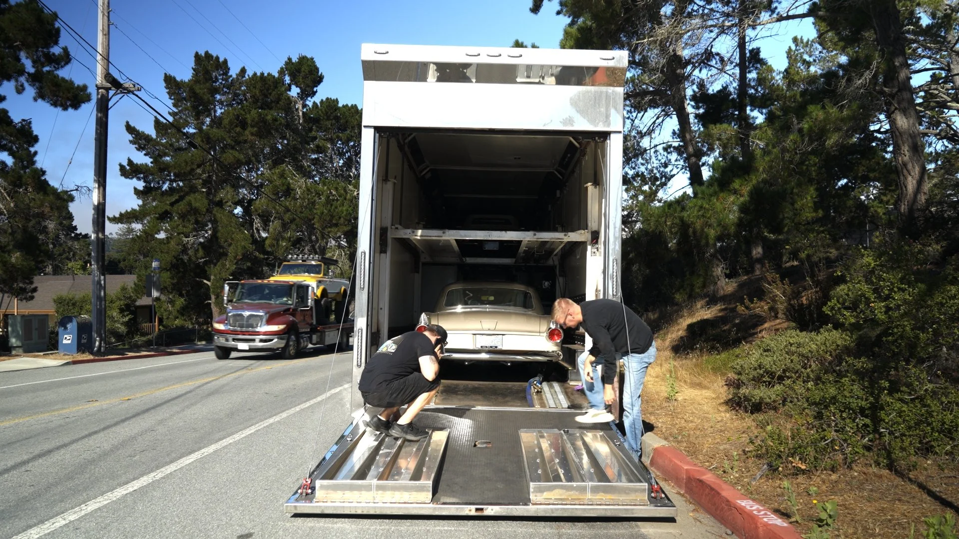 Crew loading custom car into trailer before Barrett-Jackson Cup auction event.