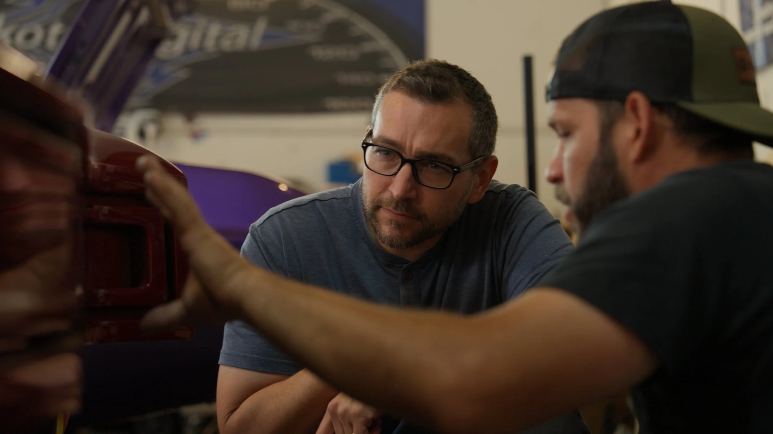 Builder and team member discussing body alignment and design decisions during All American Hot Rods competition build