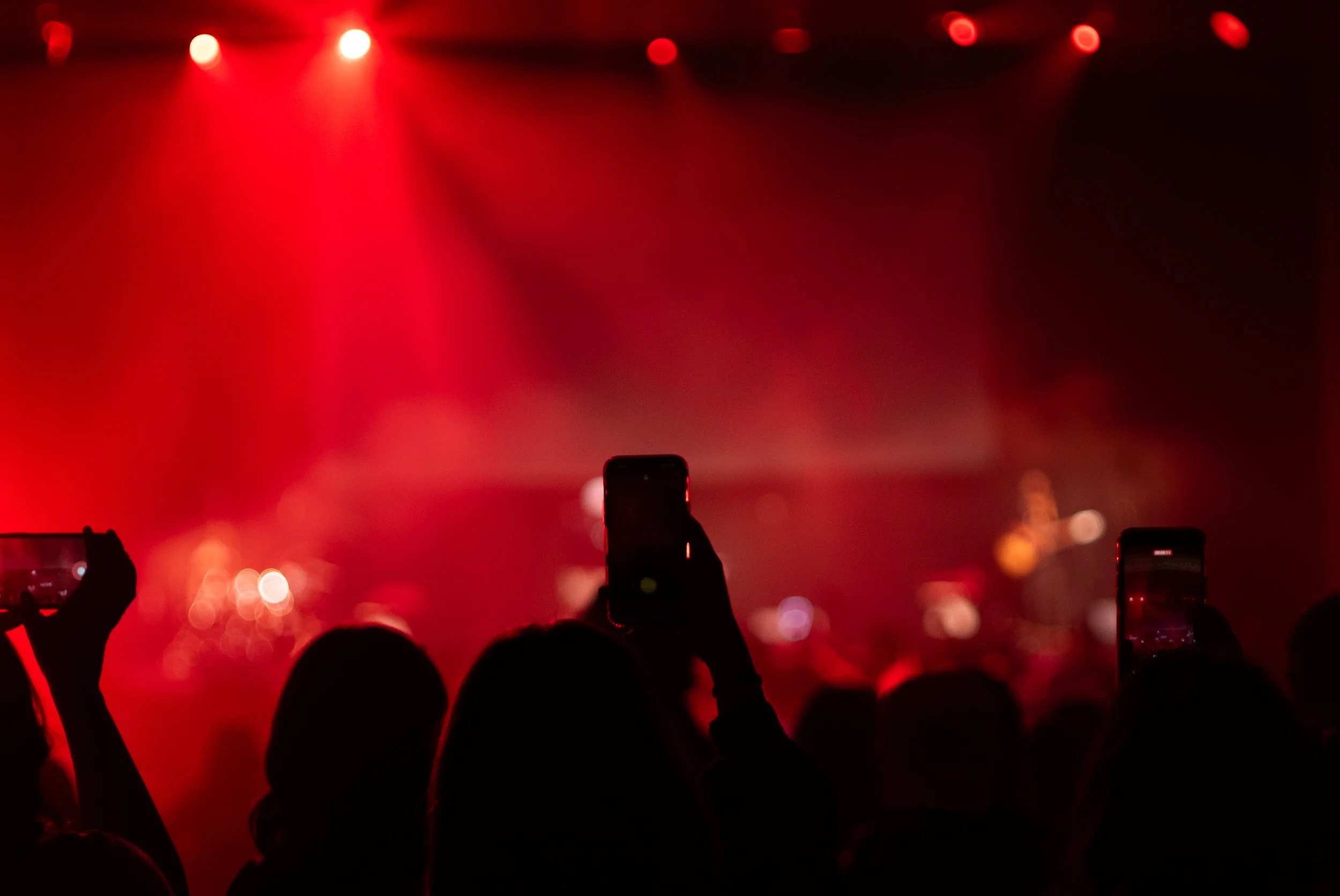 Live event video production capturing an audience member photographing a massive concert crowd during an event produced by Ragtown Media