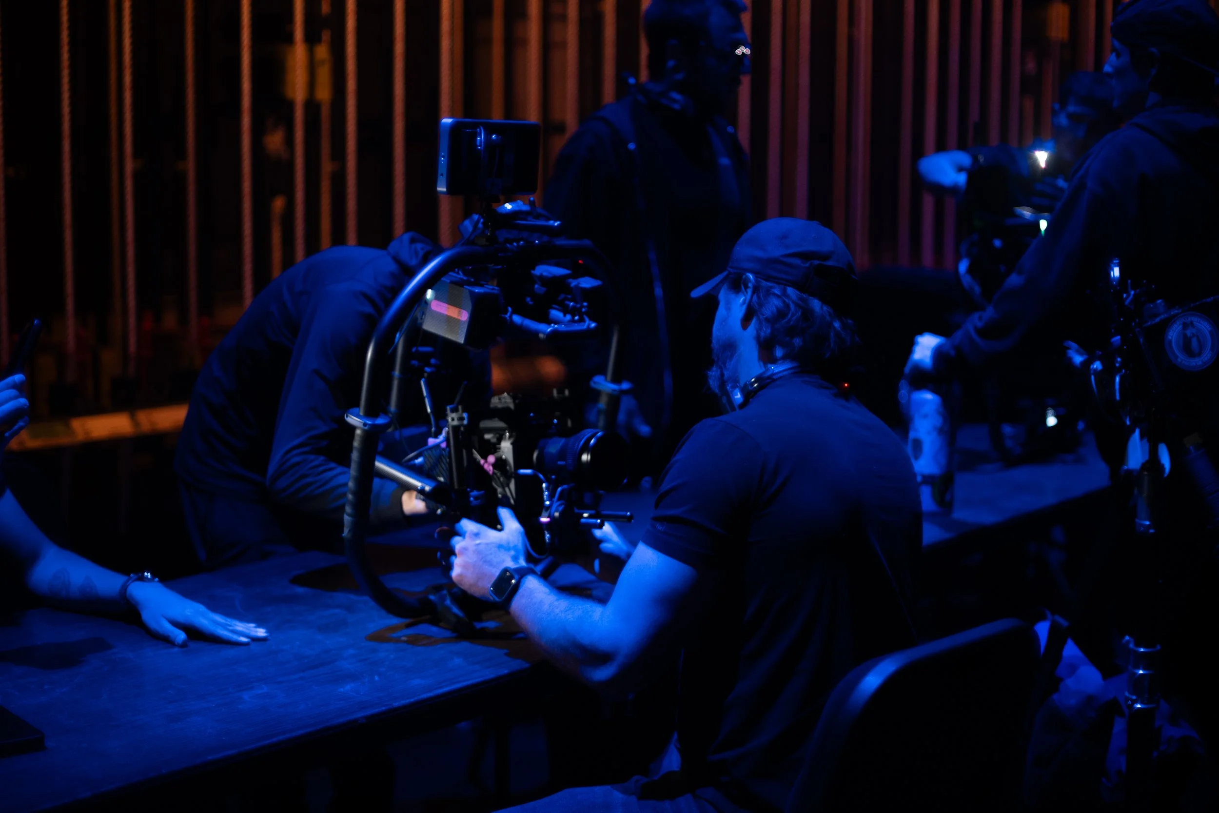 Film director and cinematography team setting up camera and lighting on production set