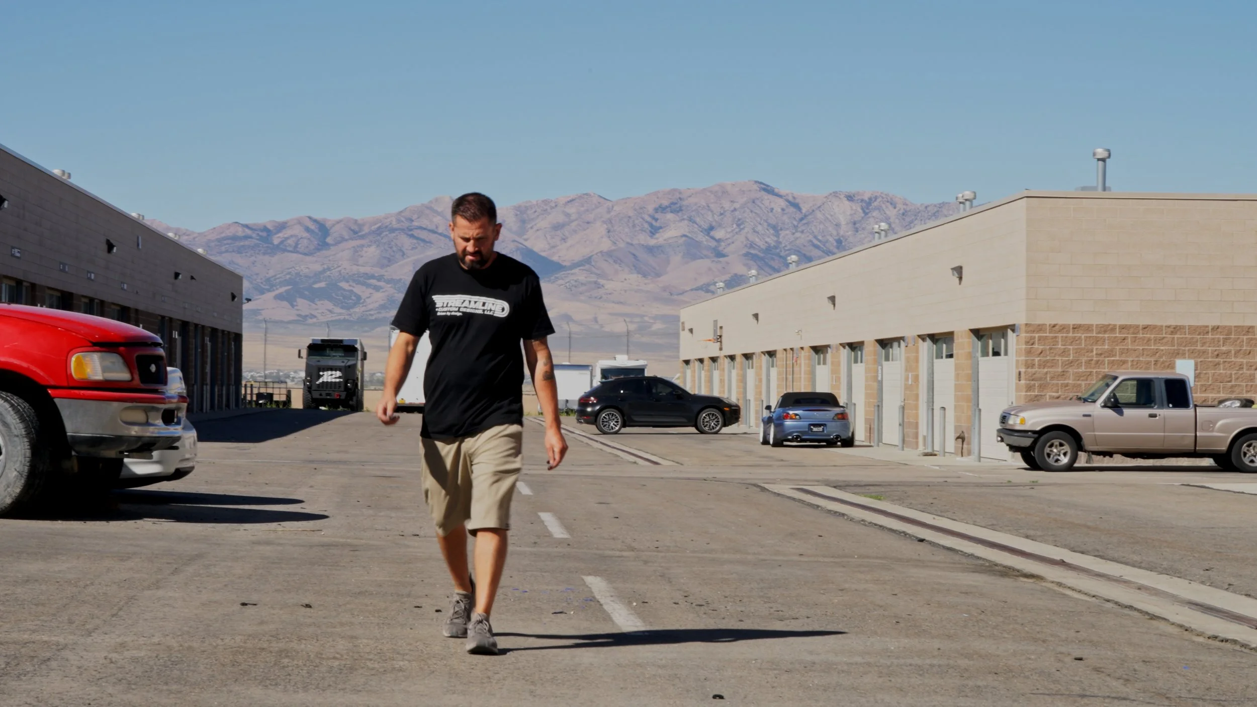 Streamline builder walking outside Salt Lake City performance shop during Barrett-Jackson Cup production filming