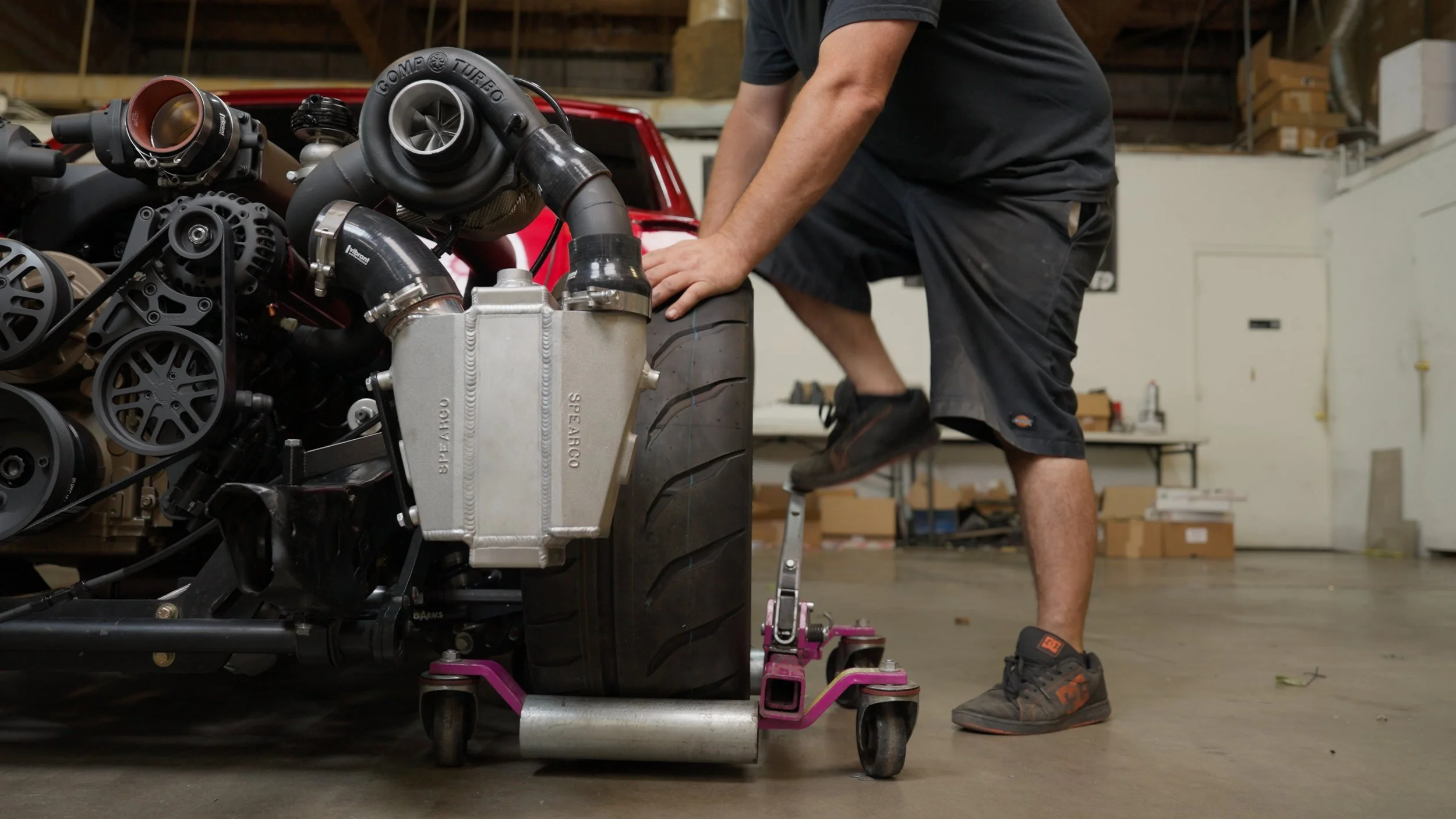 Automotive builder installing high-performance engine components during Barrett-Jackson Cup build process