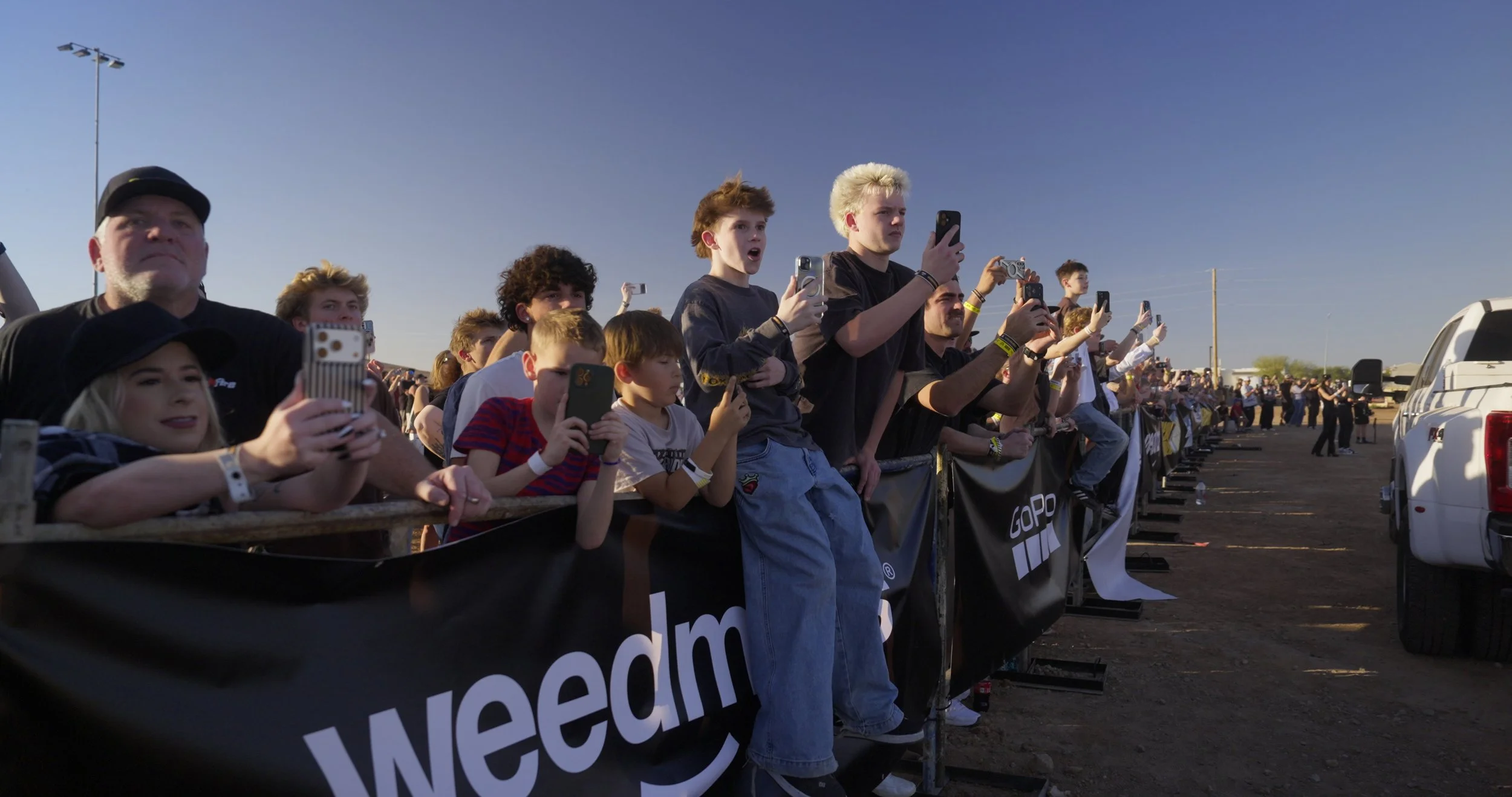 Crowd cheering behind barricade at Record Breakers action sports event