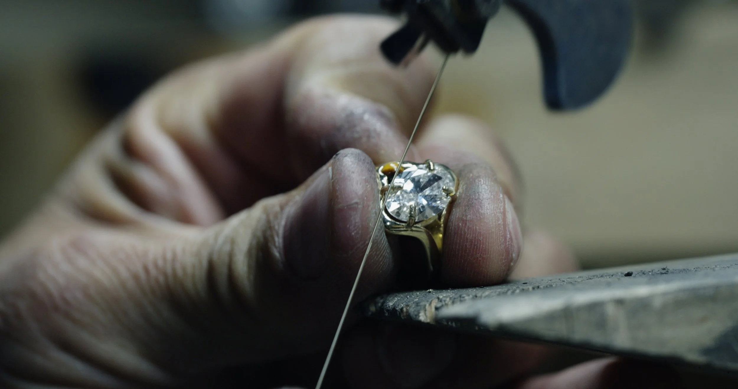 Setting the diamond into a custom engagement ring during the jewelry making process.