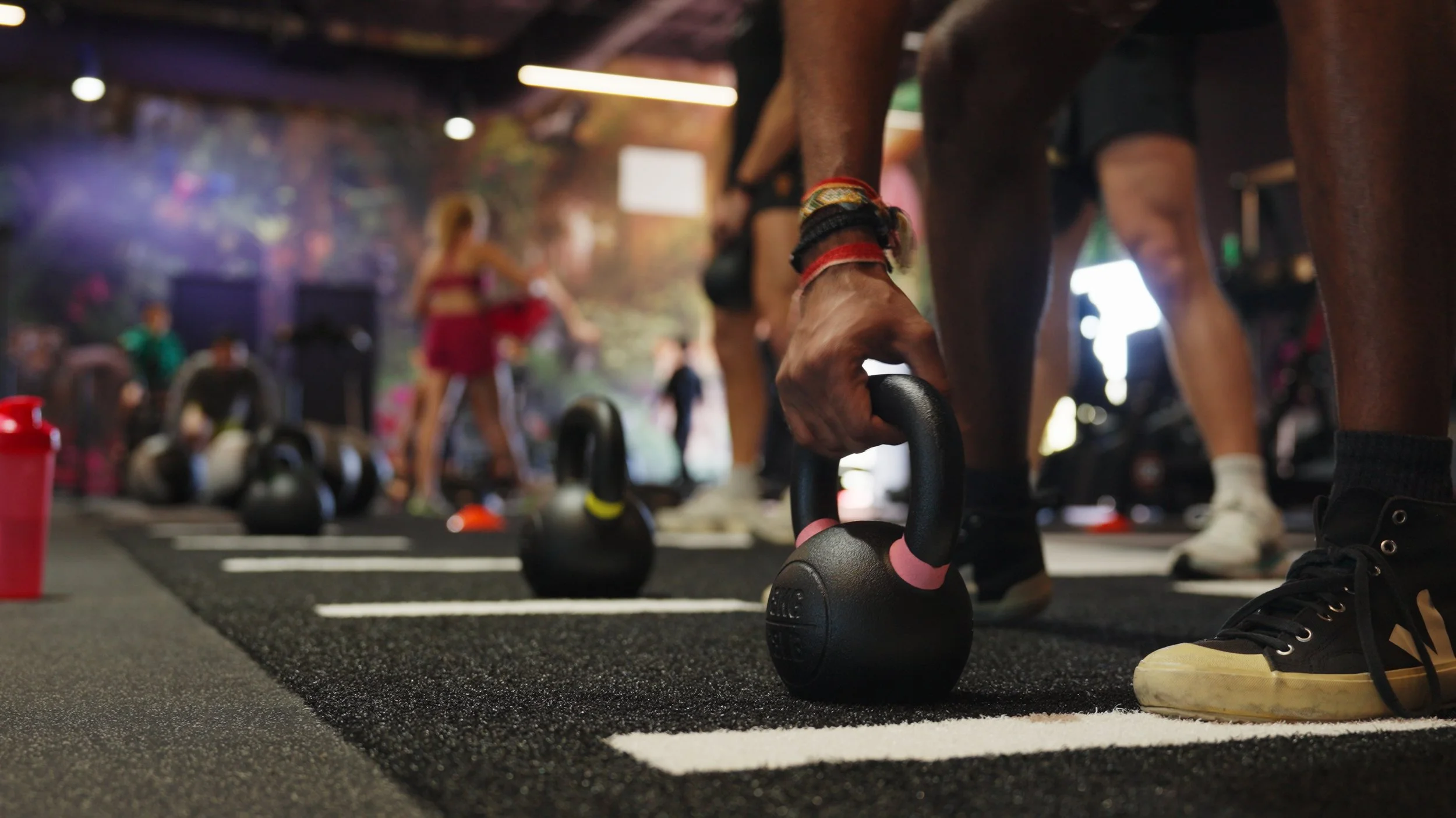 Close-up of an athlete lifting a kettlebell during a workout session at Hive Fit Club.