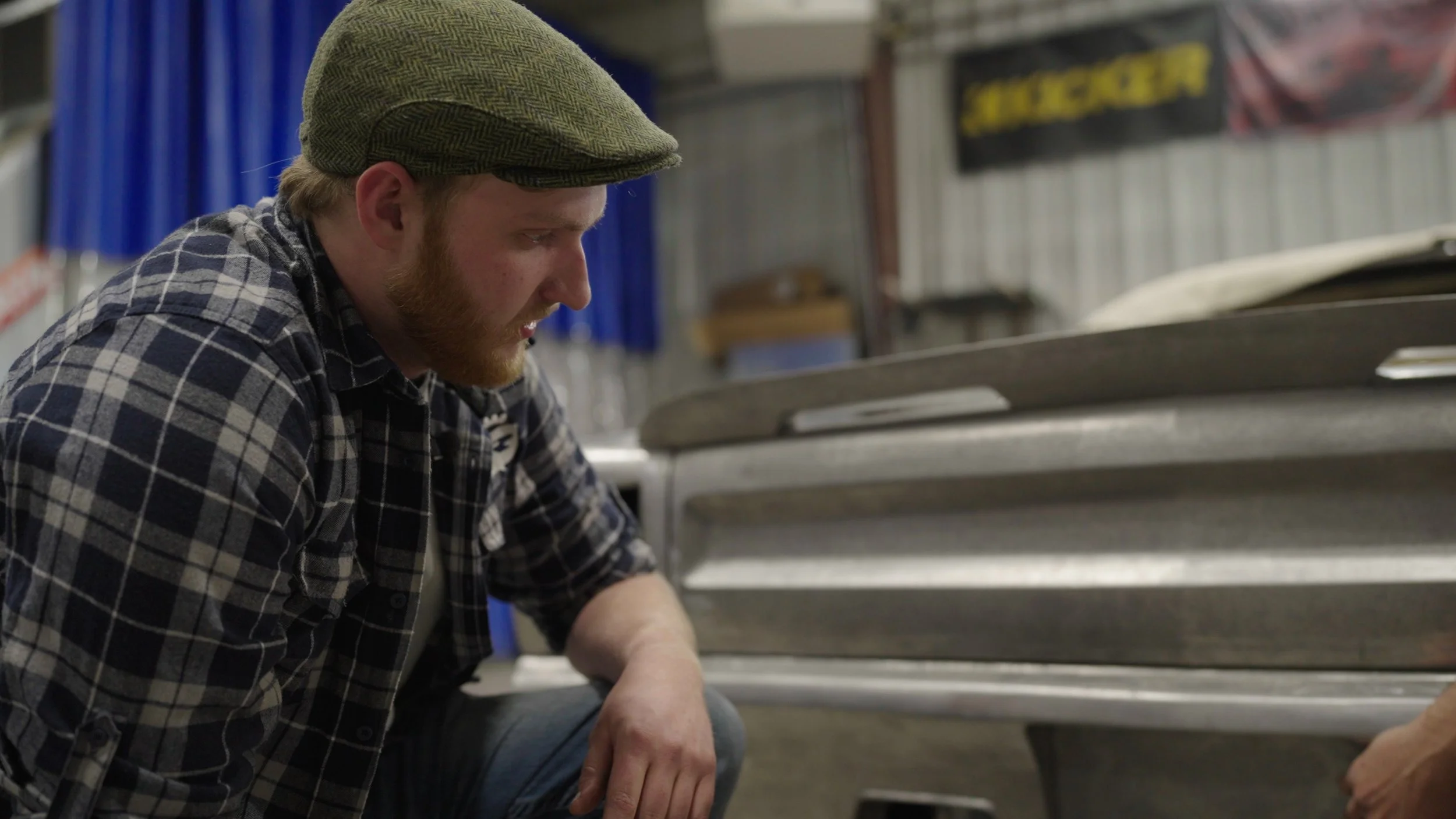 Builder at Revision Hot Rods shaping custom metal panels during production for the Barrett-Jackson Cup documentary series in Rapid City, South Dakota.