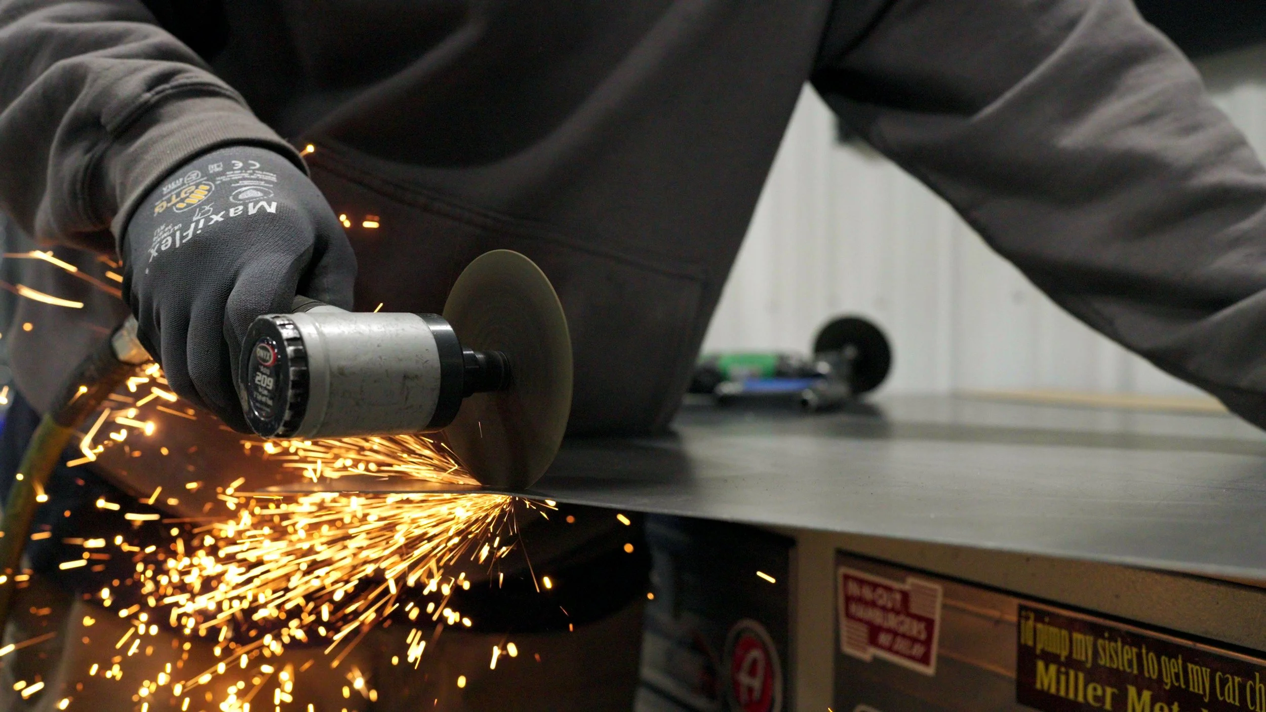 Close-up of metal fabrication sparks flying during custom car build for the Barrett-Jackson Cup series.