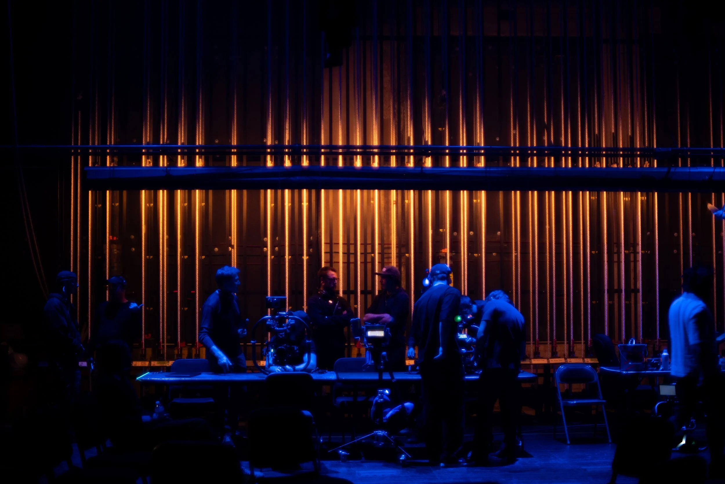 Documentary and live event production crew coordinating multi-camera coverage on stage at the Orpheum Theatre