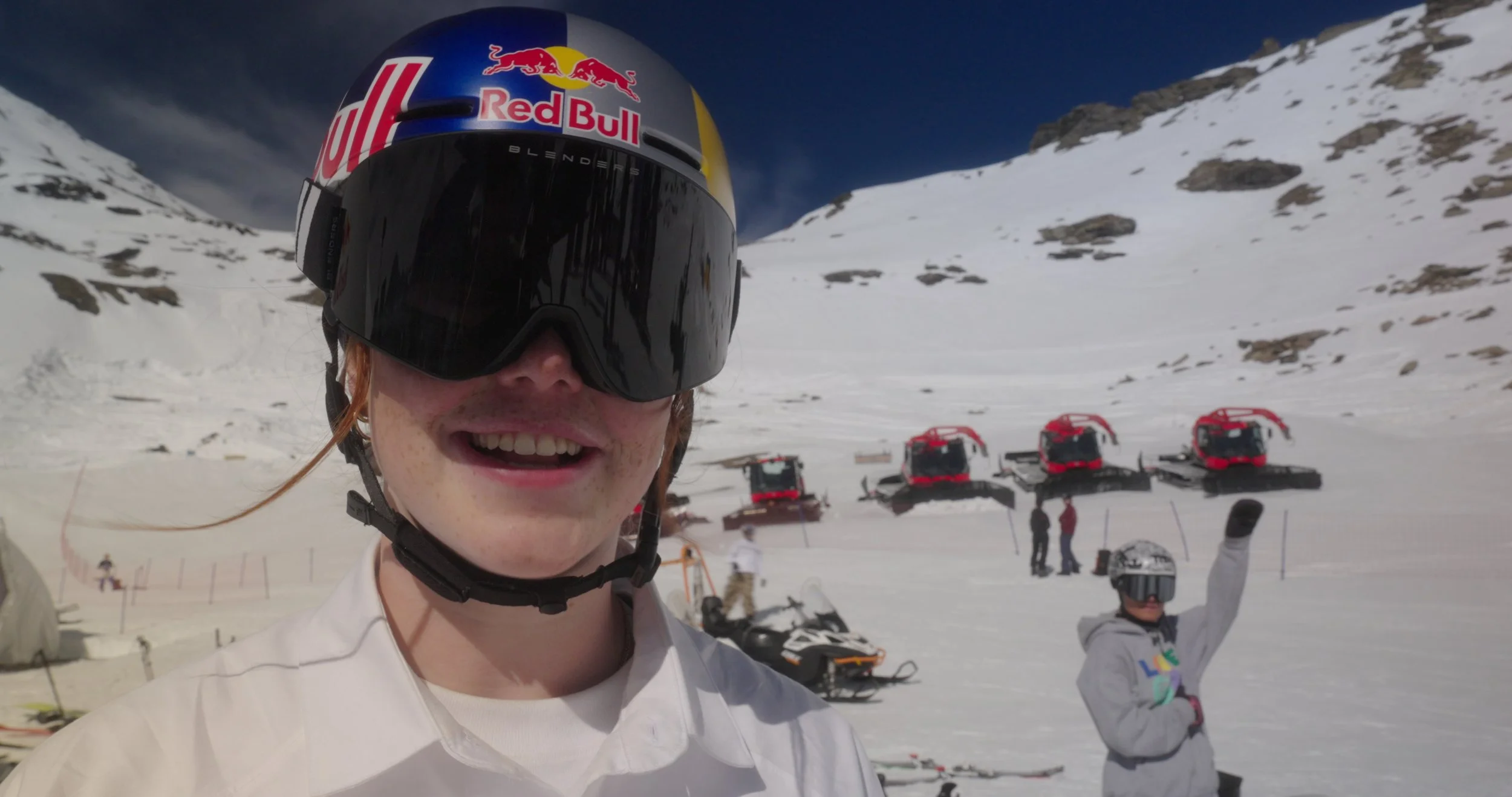 Behind-the-scenes snowboard athlete near snowcat equipment during Swatch Nines build phase in Switzerland.