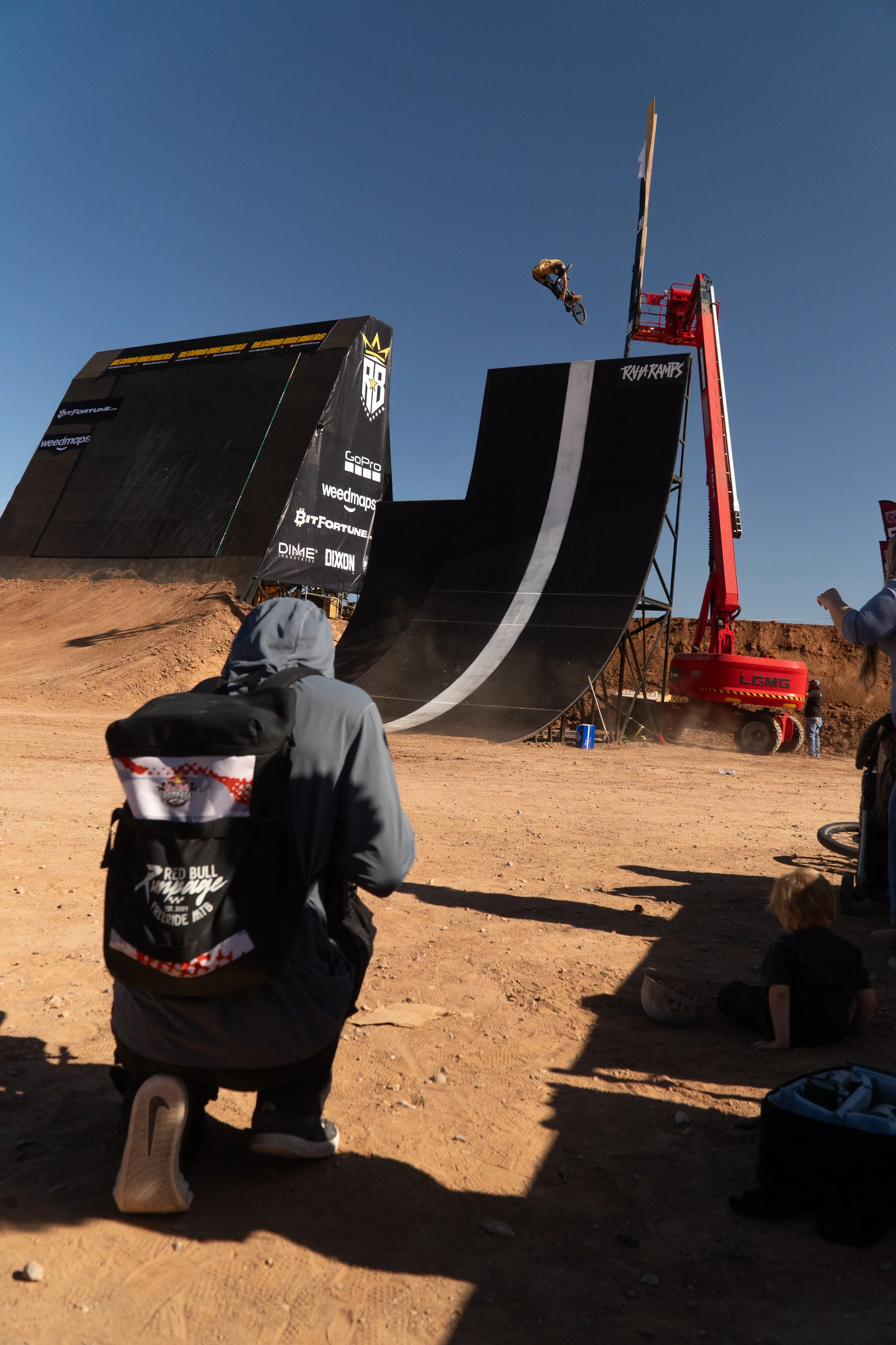 Camera operator filming large stunt ramp during live action sports event