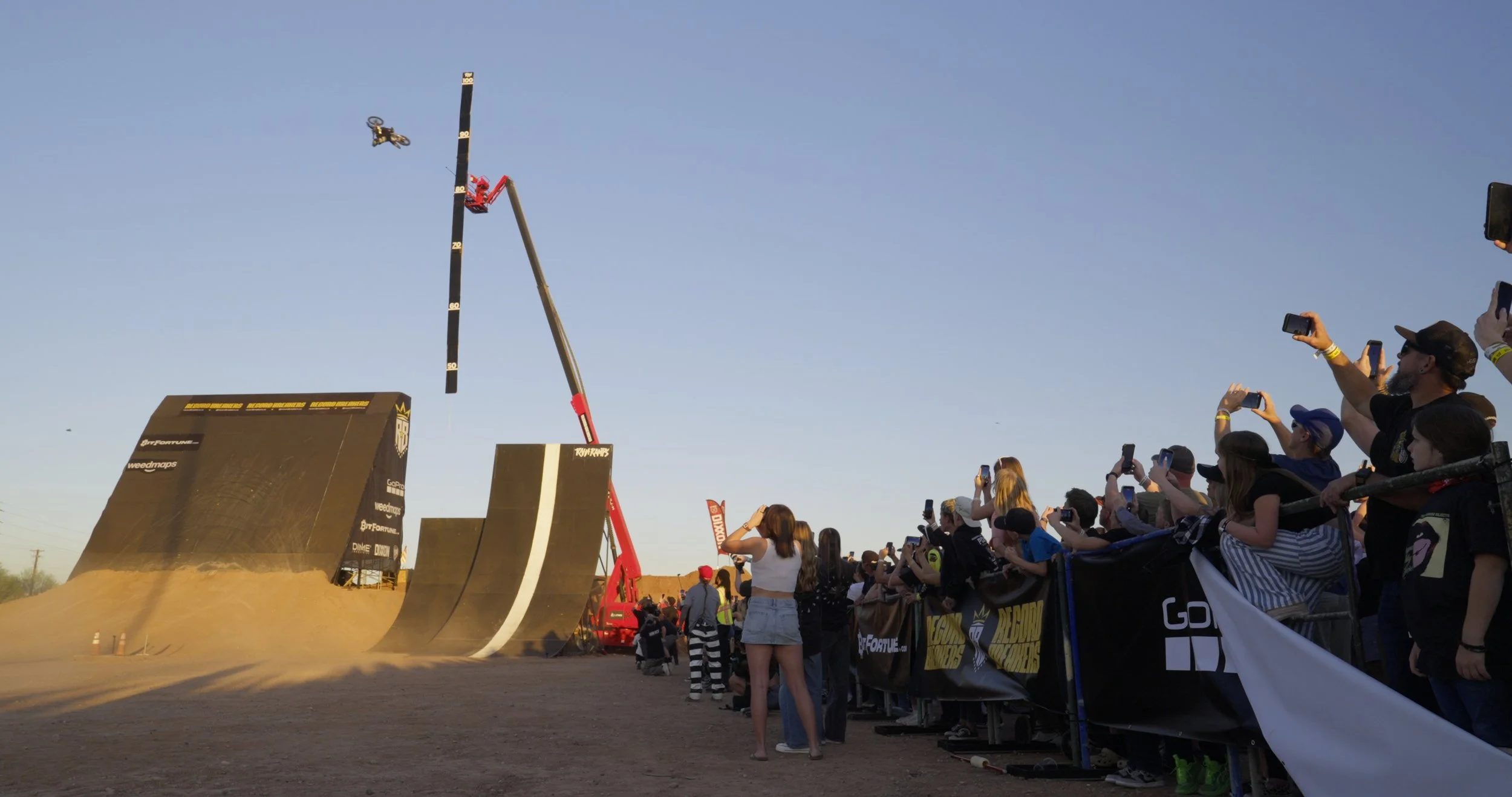 Massive custom-built stunt ramp at Record Breakers event with large crowd gathered during live extreme sports competition in Arizona