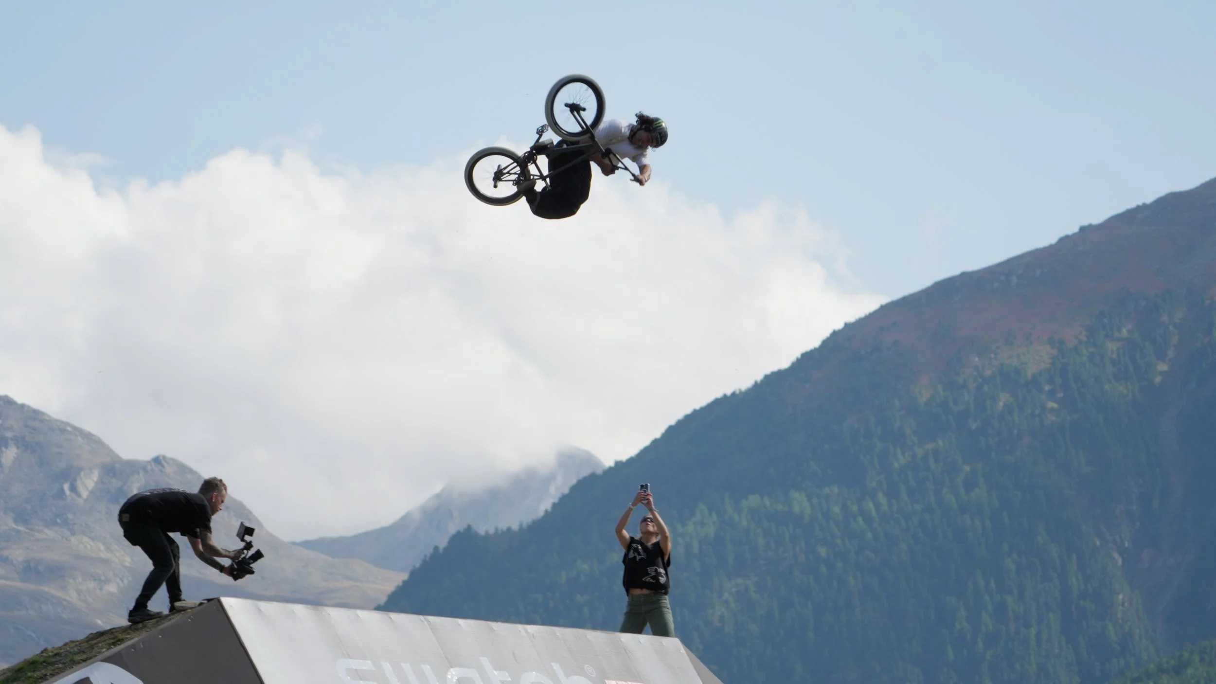 Professional BMX athlete performing a 360 invert during Swatch Nines MTB event in Austria, filmed with high-speed action sports video production techniques.
