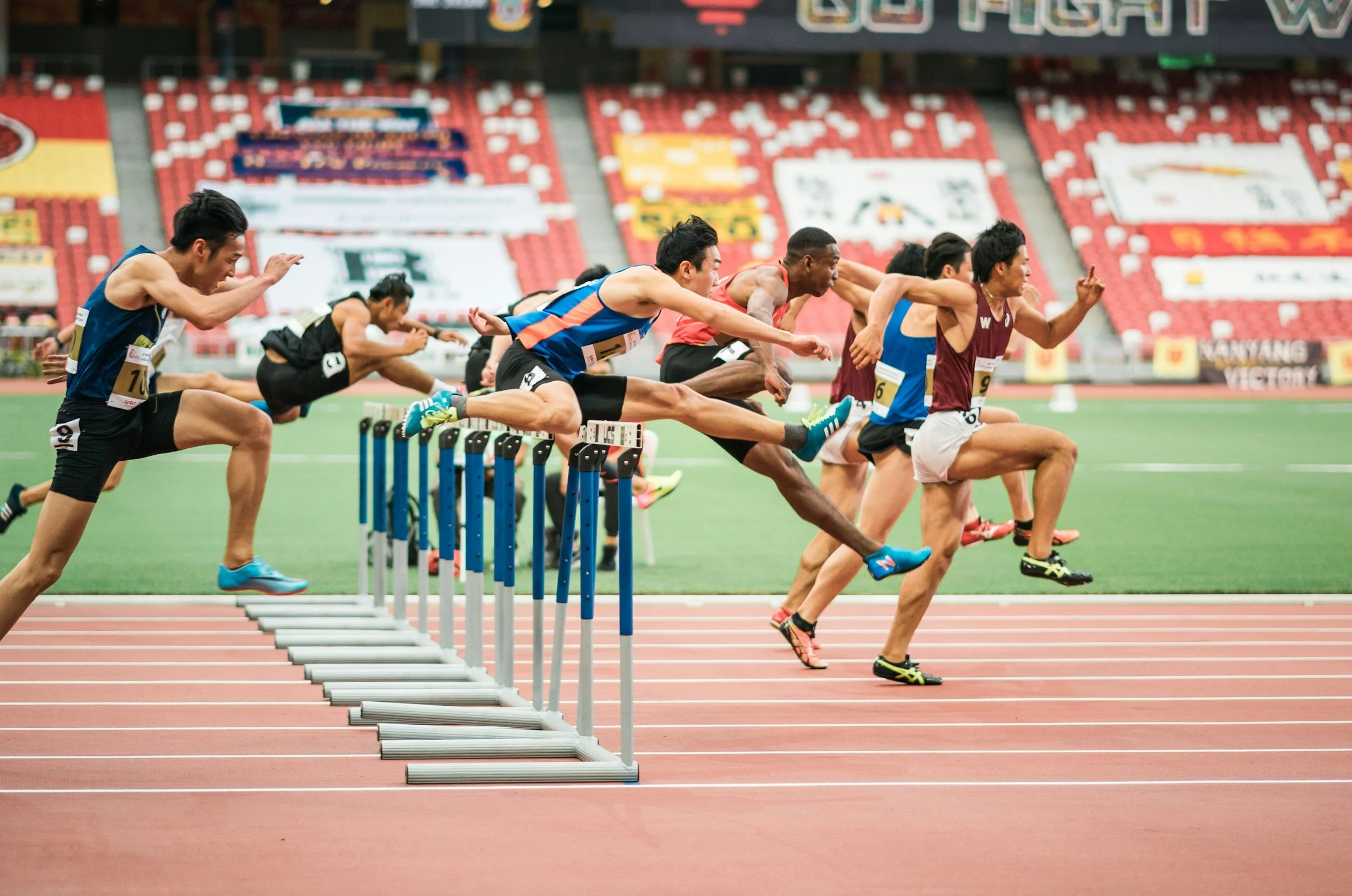 track and field athletes doing hurdles.