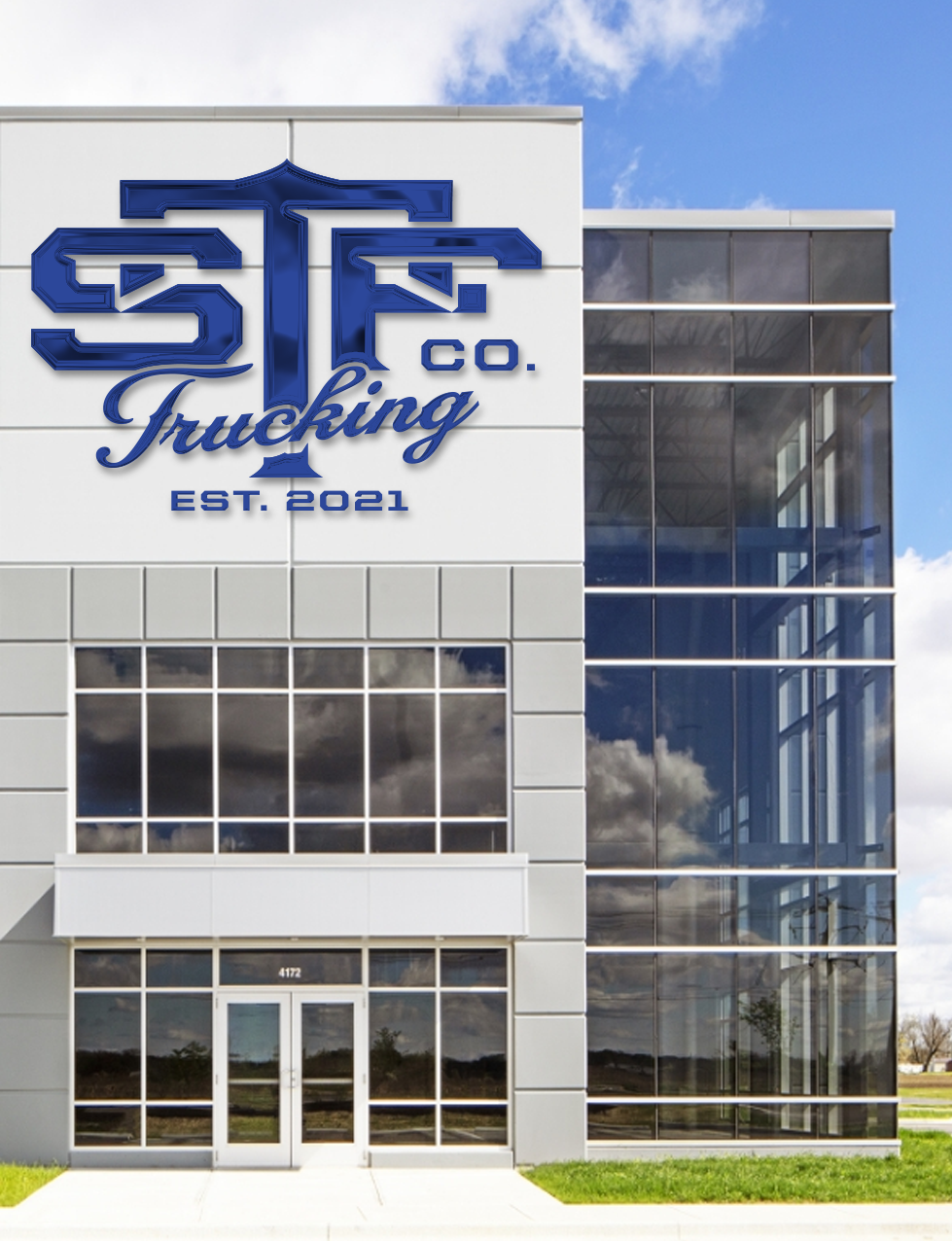 Front view of a modern commercial building with reflective glass windows and a sign that reads 'ST & F Co. Trucking EST. 2021' in blue lettering.