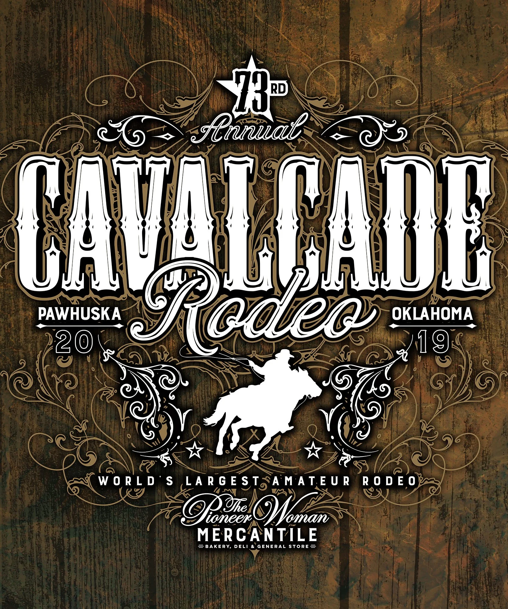A poster for the 73rd Annual Cowtown Rodeo, with a dark wood background and ornate white decorative elements. It features an illustration of a cowboy riding a bucking horse at the bottom. The event is held in Pawhuska, Oklahoma, in 2019, and promoted as the world's largest amateur rodeo. Additional text mentions the Pioneers Woman Mercantile, a bakery, deli, and general store.