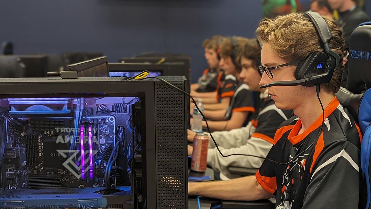 A young man in headphones, deeply focused on his esports match, showcasing his passion for video games.