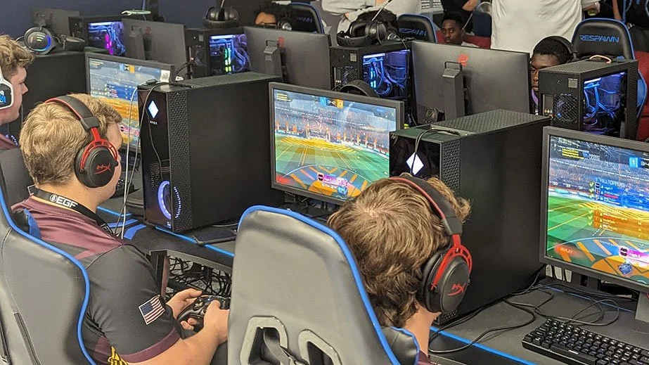 A dynamic scene of gamers in a room, fully engaged in an esports match, surrounded by computers.