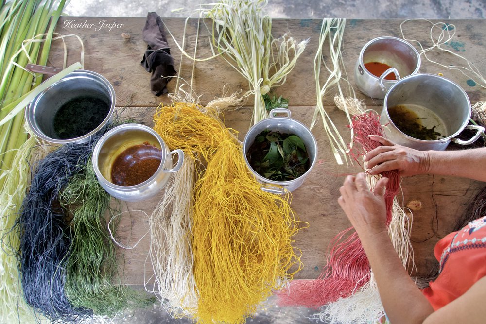 Palm fibers are dried before being boiled in these natural dyes.