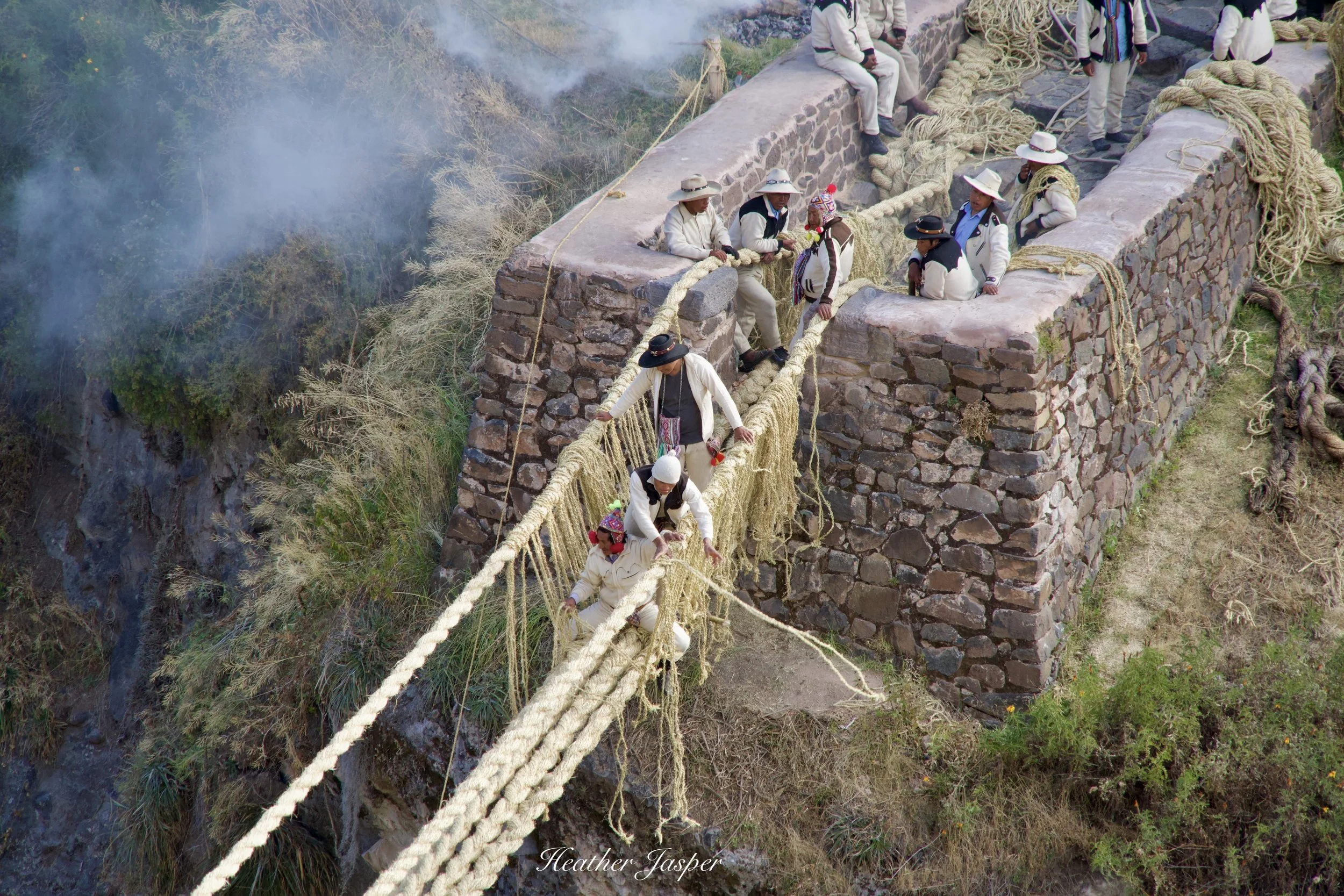 After the main ropes are pulled across men begin to build the sides.