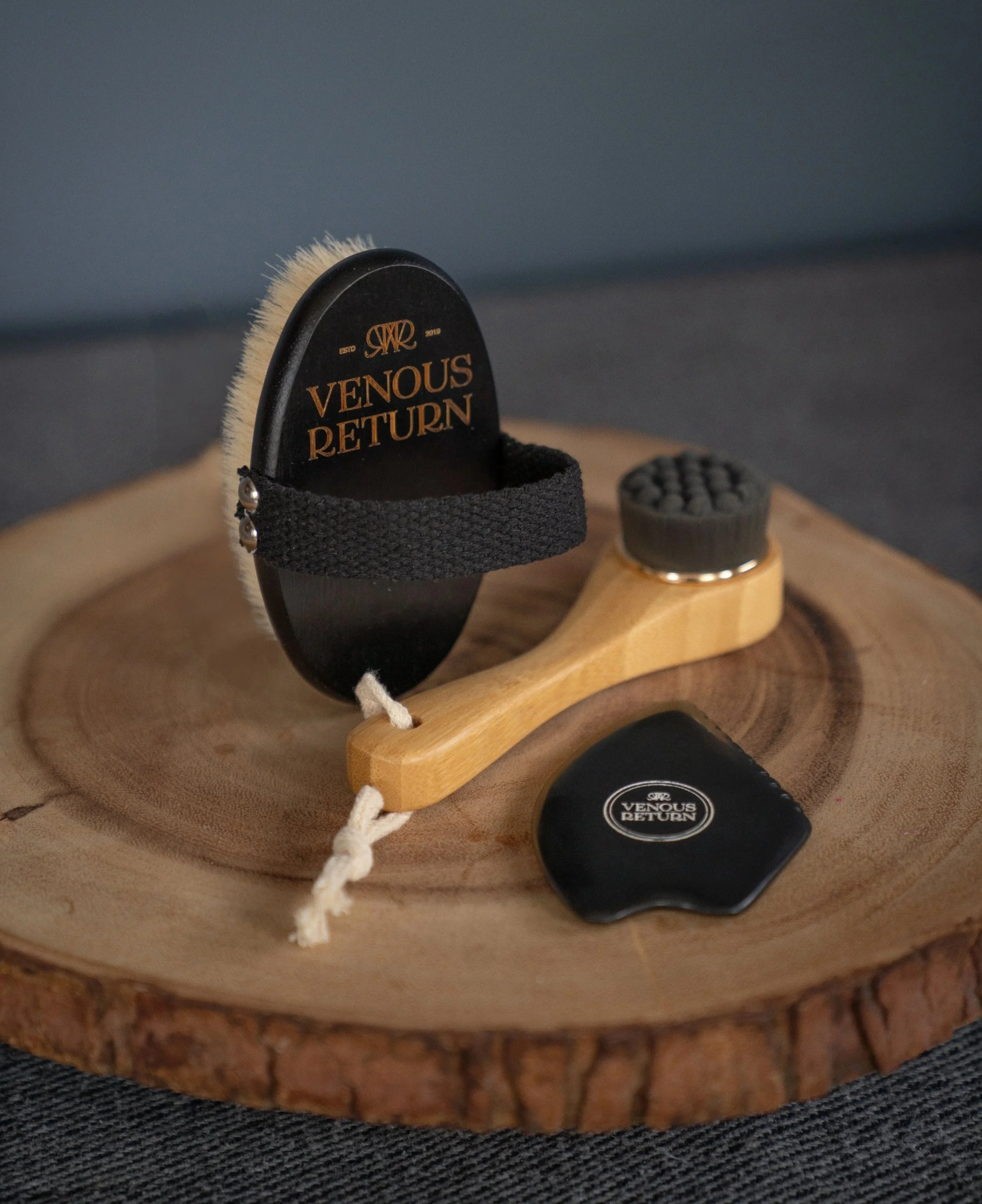 The Flow Collection by Venous Return Healing, tools for lymphatic drainage and self massage including the Bian Gua Sha Stone, Bamboo Facial Dry Brush and Body Dry Brush.