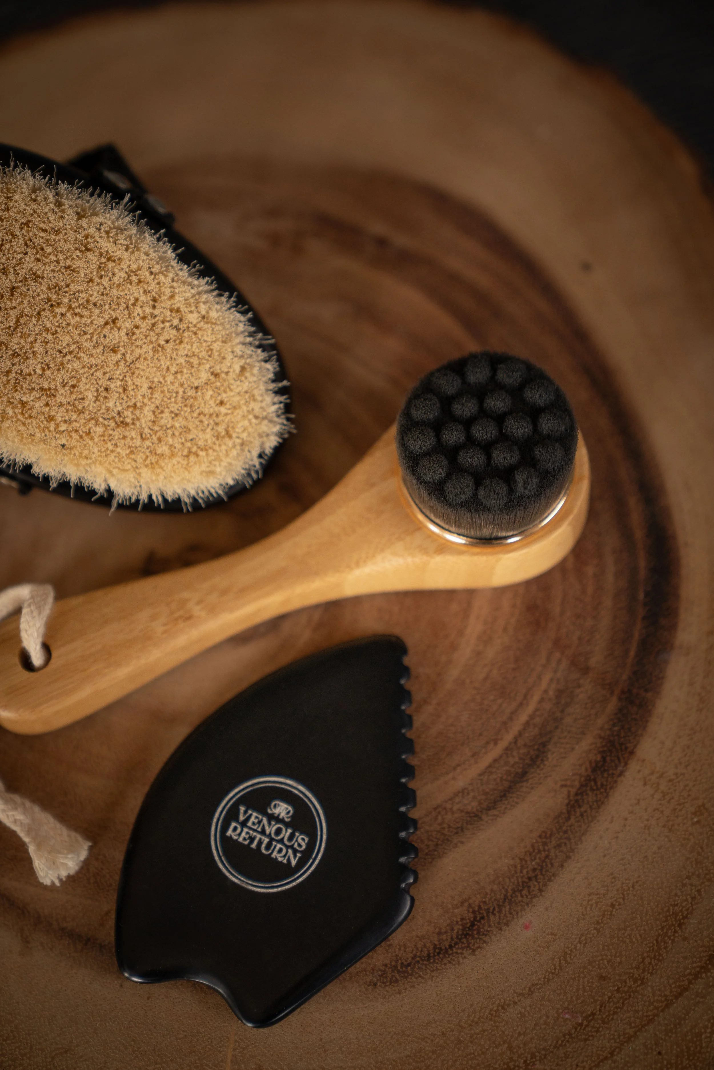 The Flow Collection by Venous Return Healing, tools for lymphatic drainage and self massage including the Bian Gua Sha Stone, Bamboo Facial Dry Brush and Body Dry Brush.