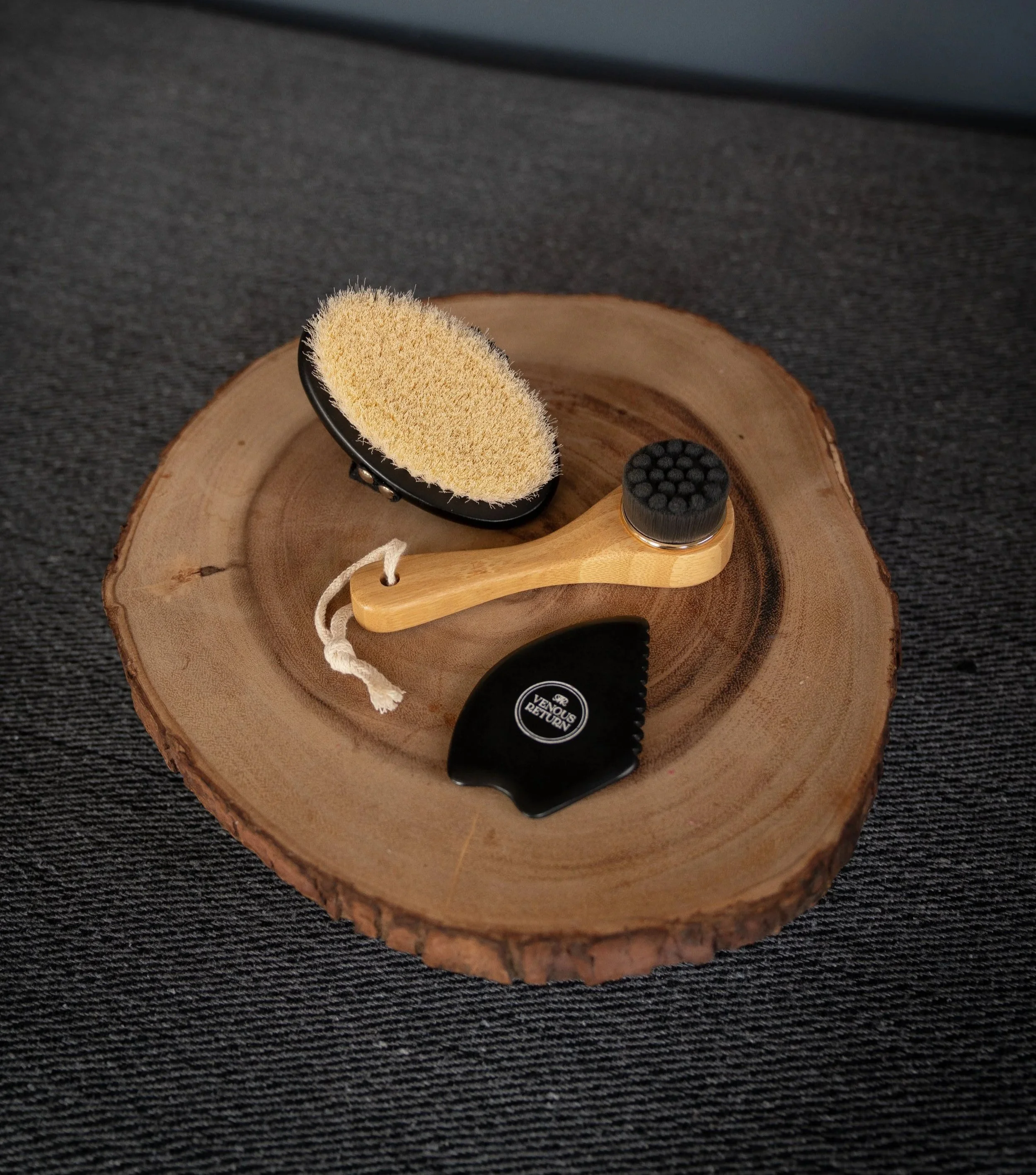The Flow Collection by Venous Return Healing, tools for lymphatic drainage and self massage including the Bian Gua Sha Stone, Bamboo Facial Dry Brush and Body Dry Brush.