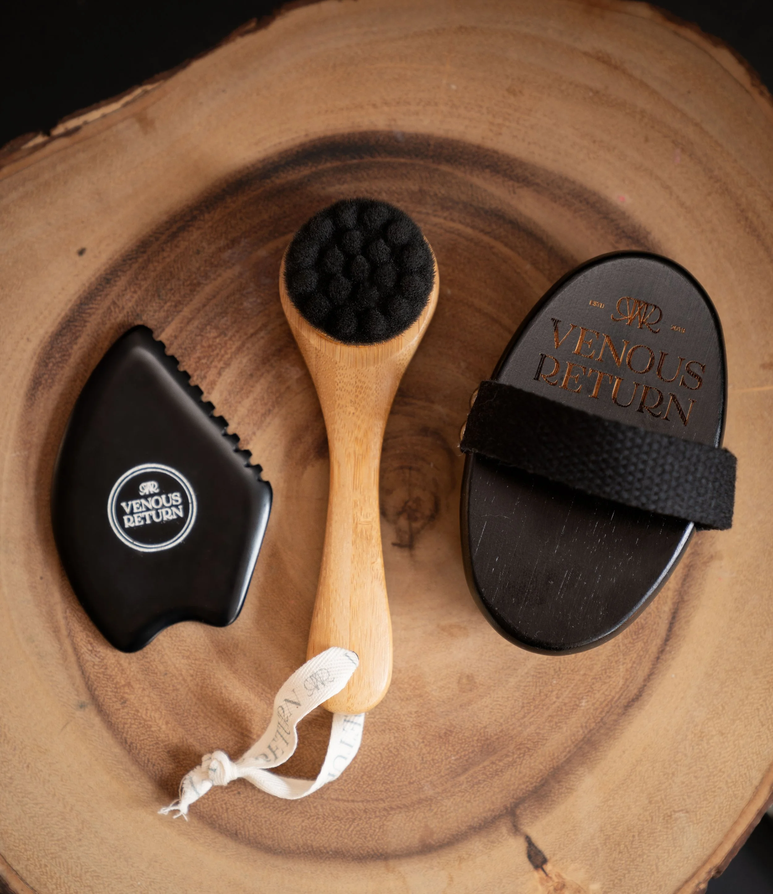 The Flow Collection by Venous Return Healing, tools for lymphatic drainage and self massage including the Bian Gua Sha Stone, Bamboo Facial Dry Brush and Body Dry Brush.