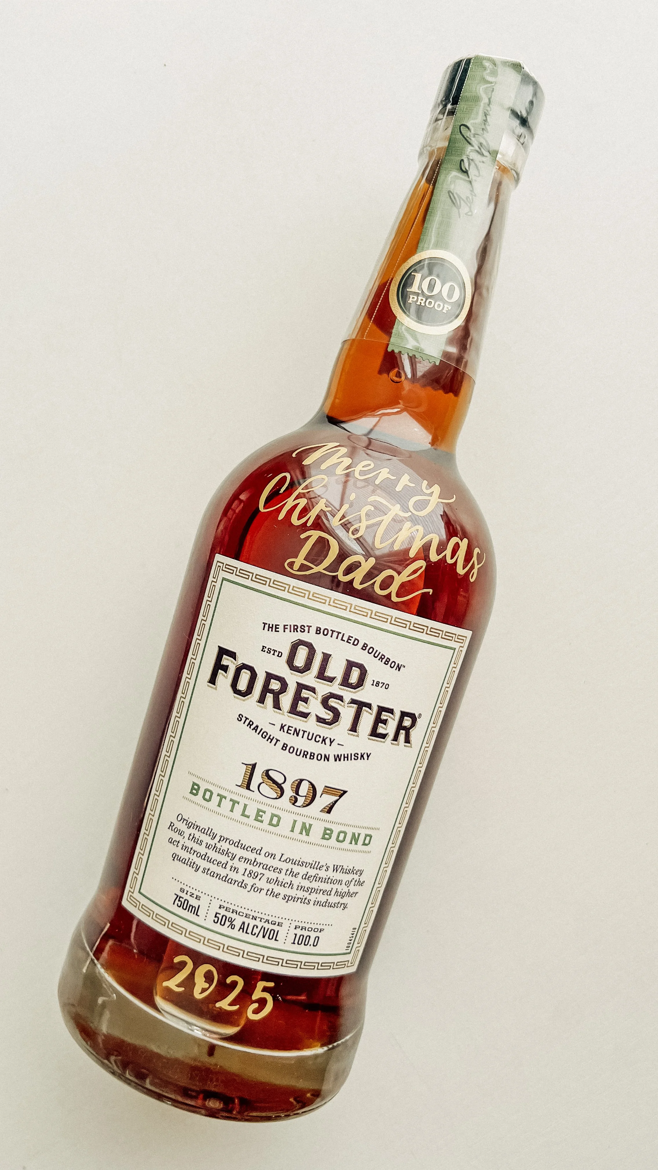 A bottle of Old Forester bourbon whiskey with a holiday message on it.