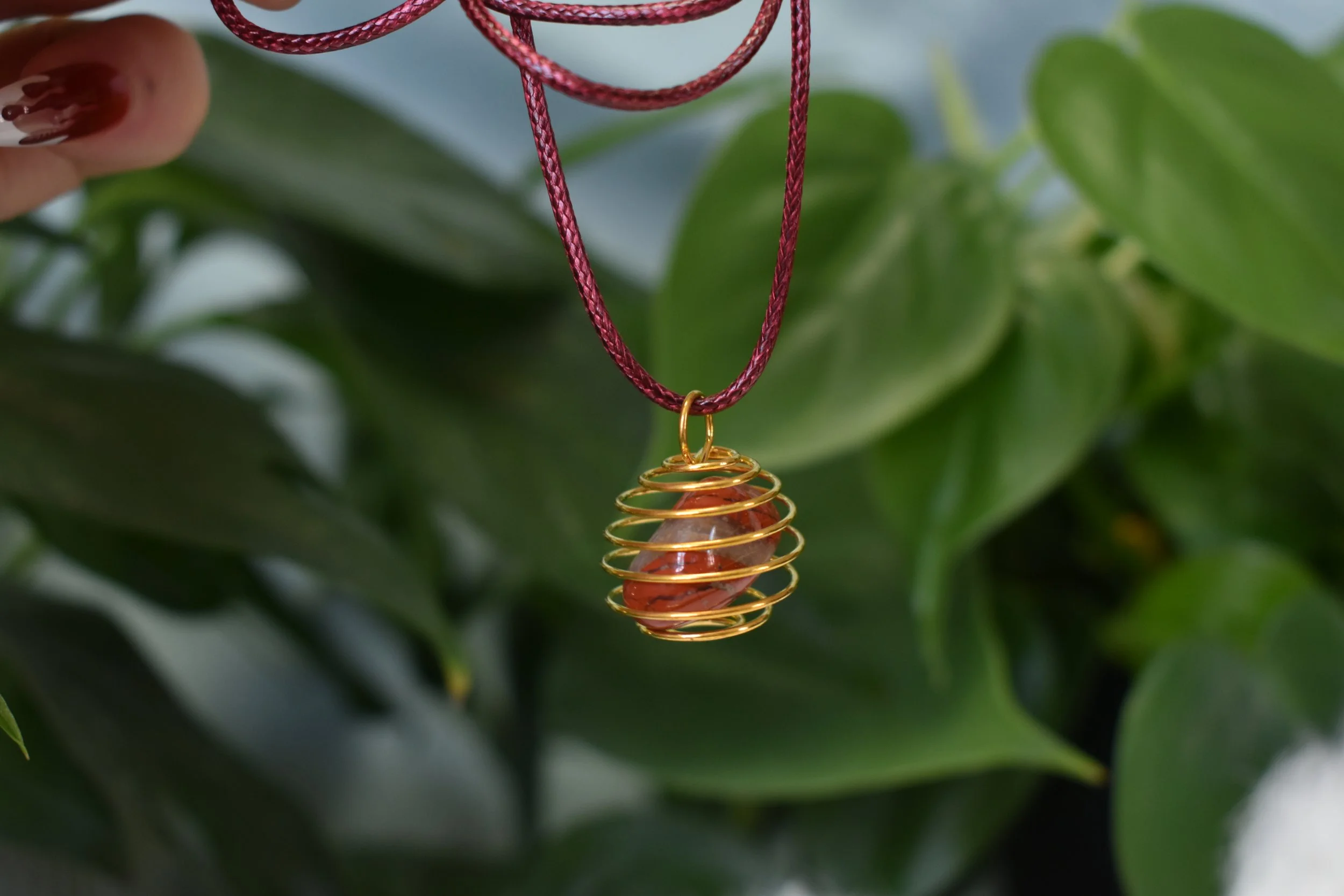 Red jasper tumble on a maroon cord