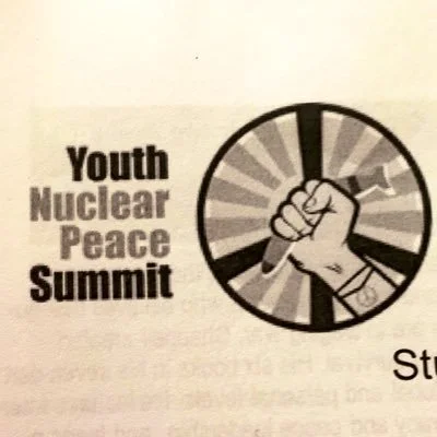 Logo for Youth Nuclear Peace Summit featuring a raised fist inside a circular symbol. This photo was taken in 2019.