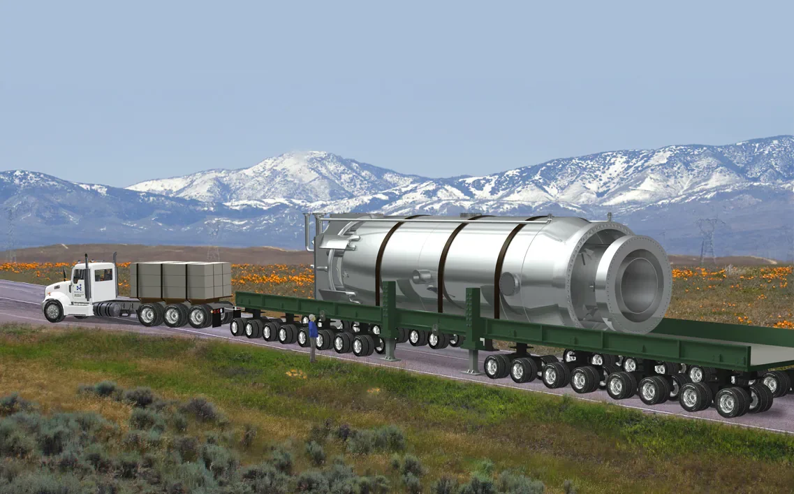 A large futuristic-looking cylindrical object being transported on a flatbed trailer by a white semi-truck traveling on a highway with mountains in the background.