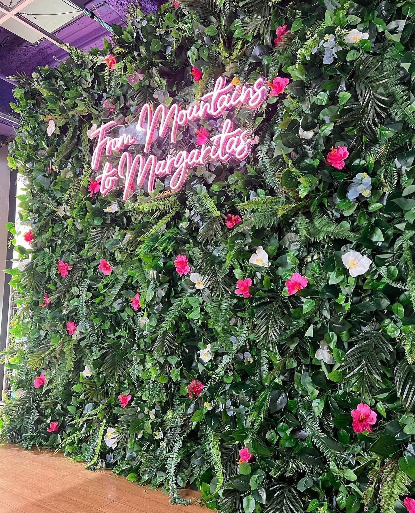 A fun and fabulous flower wall! This tropical flower wall has pink hibiscus flowers, and white orchids with an assortment of lush green foliage. Dress it up with a neon or wooden sign! Our Hibiscus Paradise tropical flower wall is perfect for birthda