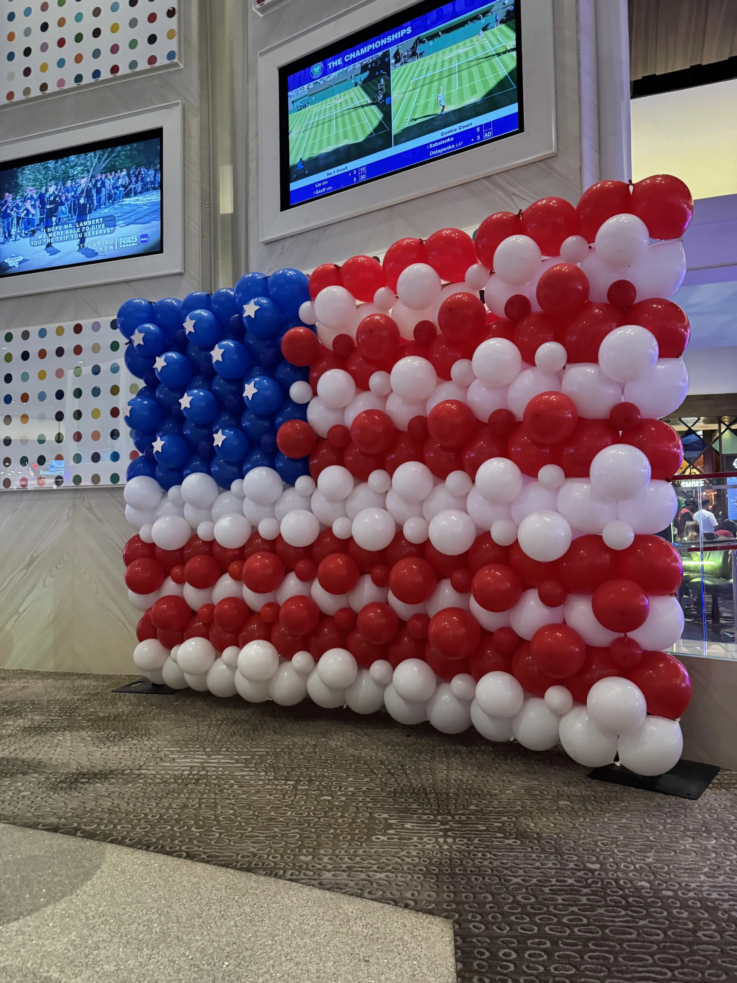 Patriotic American flag balloon wall rental in Las Vegas by Flower Walls Las Vegas. Custom Fourth of July balloon backdrop with organic red, white, and blue balloons for corporate events, casinos, and holiday celebrations.