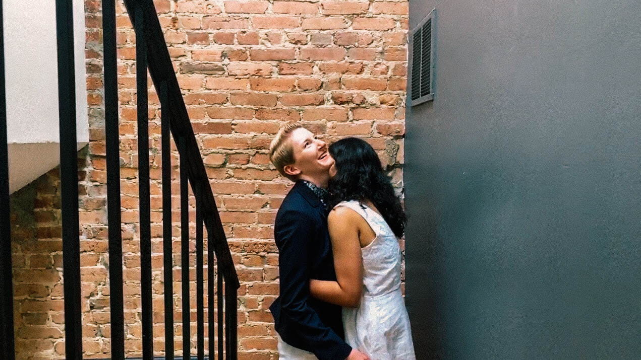 Newlywed couple embracing by a brick wall in Washington DC Shawnee Custalow Queer Wedding Photographer