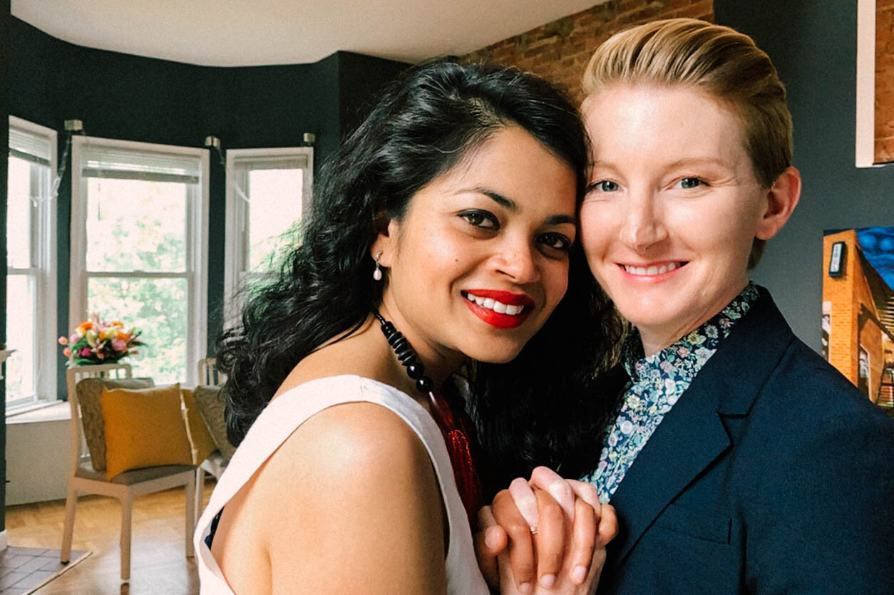 Newlyweds holding hands and smiling in their DC home Shawnee Custalow Queer Wedding Photographer