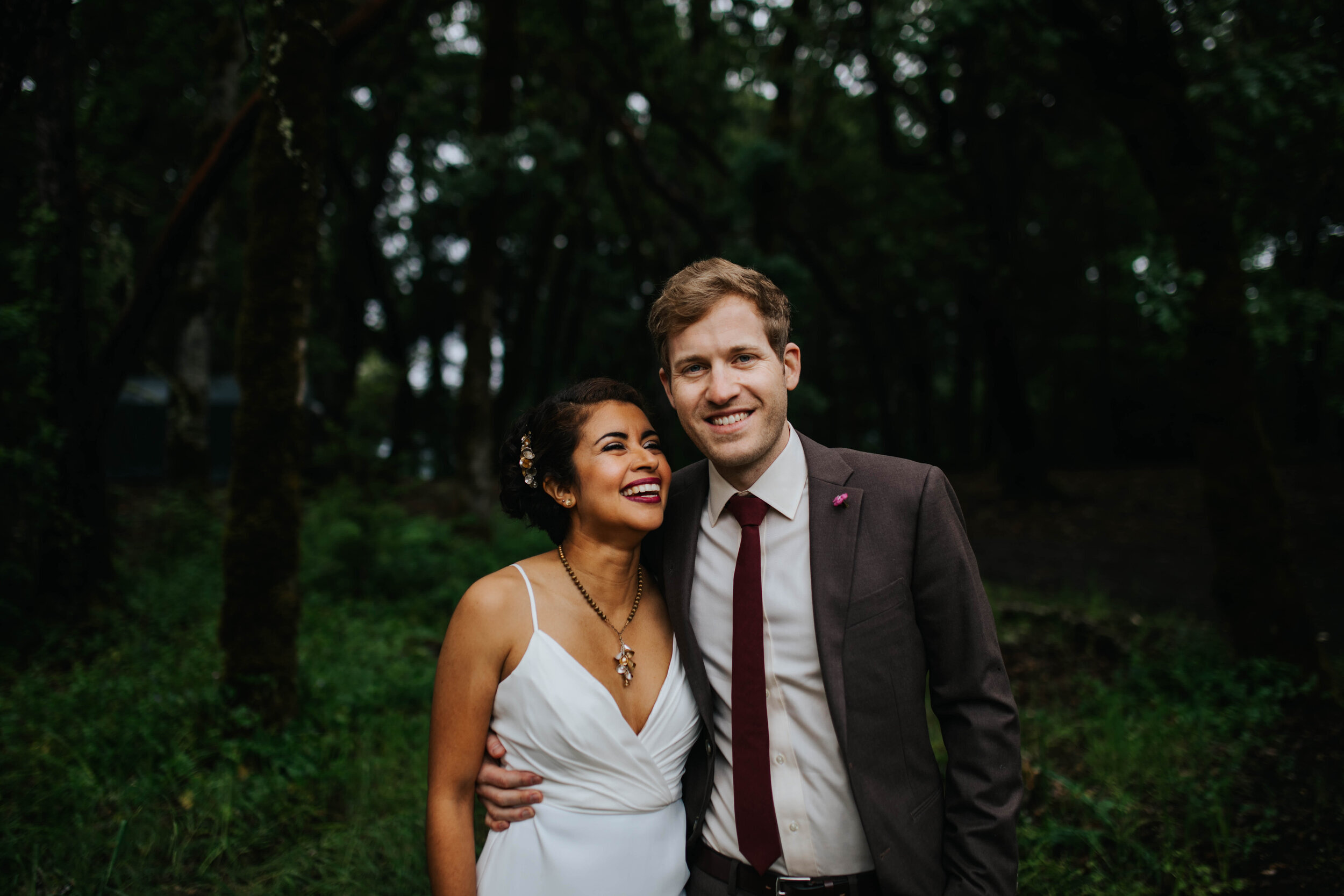 Newlywed couple smiling and embracing outside in Richmond VA Shawnee Custalow Queer Wedding Photographer