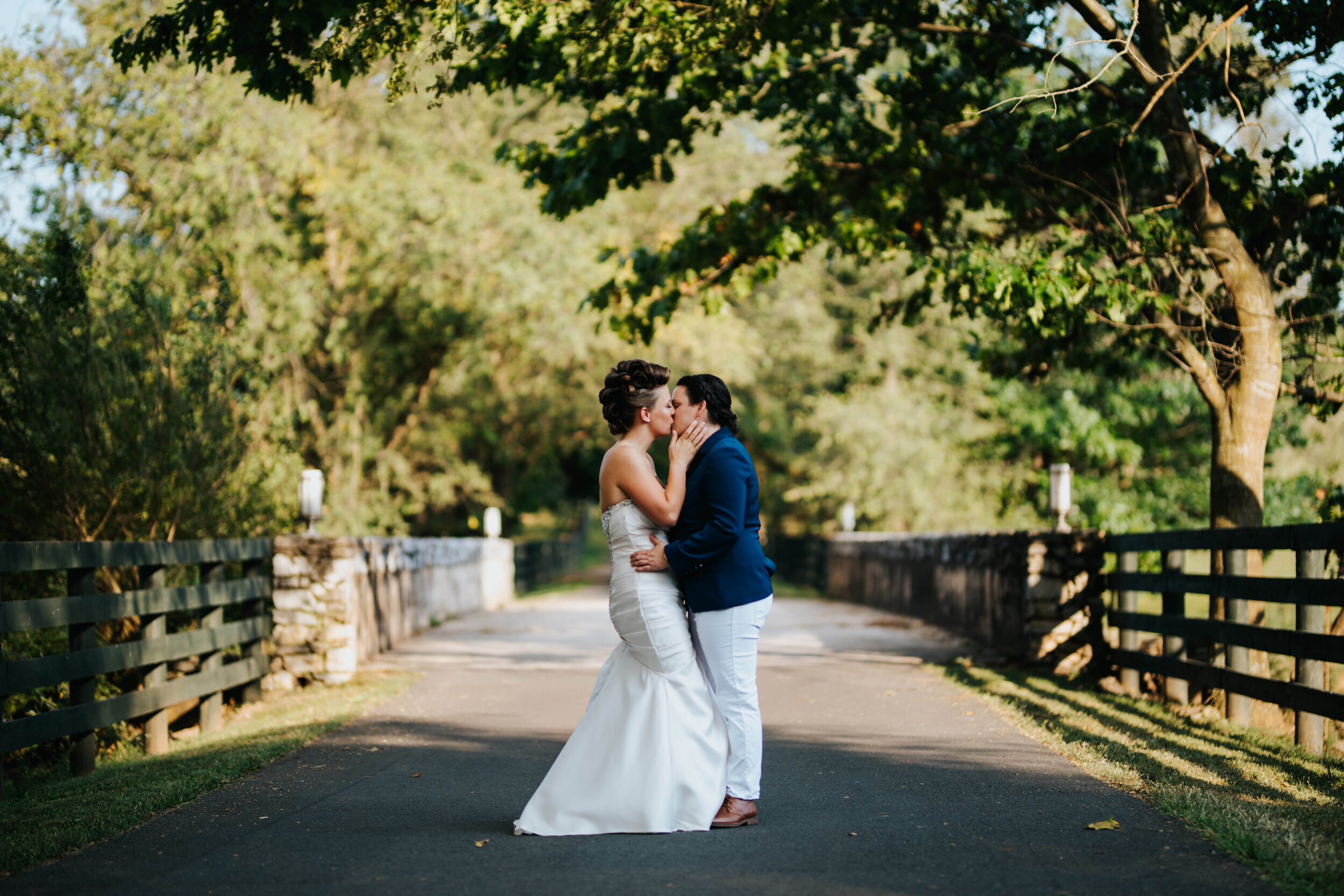 LGBTQ newlywed couple kissing on a path through a green park in RVA Shawnee Custalow Queer Wedding Photographer