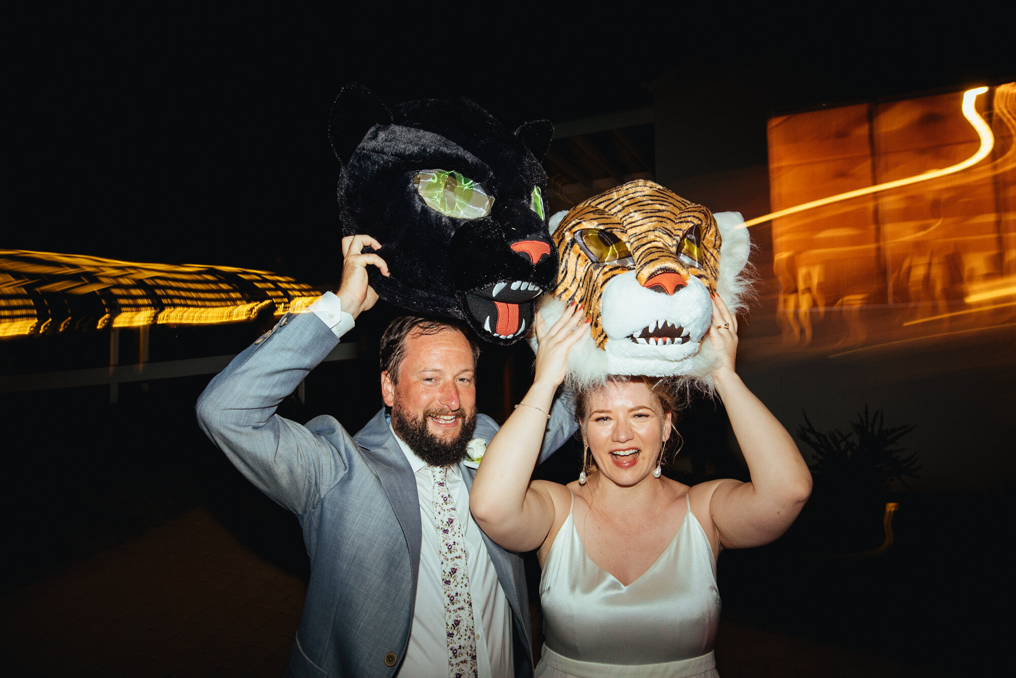 Newlywed couple with a stuffed tiger and panther mascot heads in RVA Shawnee Custalow Queer Wedding Photographer