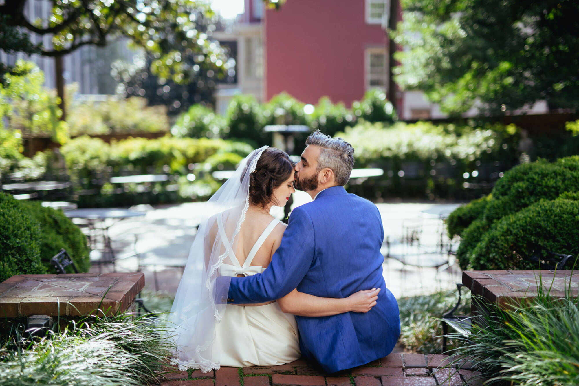 Bride being kissed on the forehead by the groom in Richmond Virginia Shawnee Custalow Queer Wedding Photographer