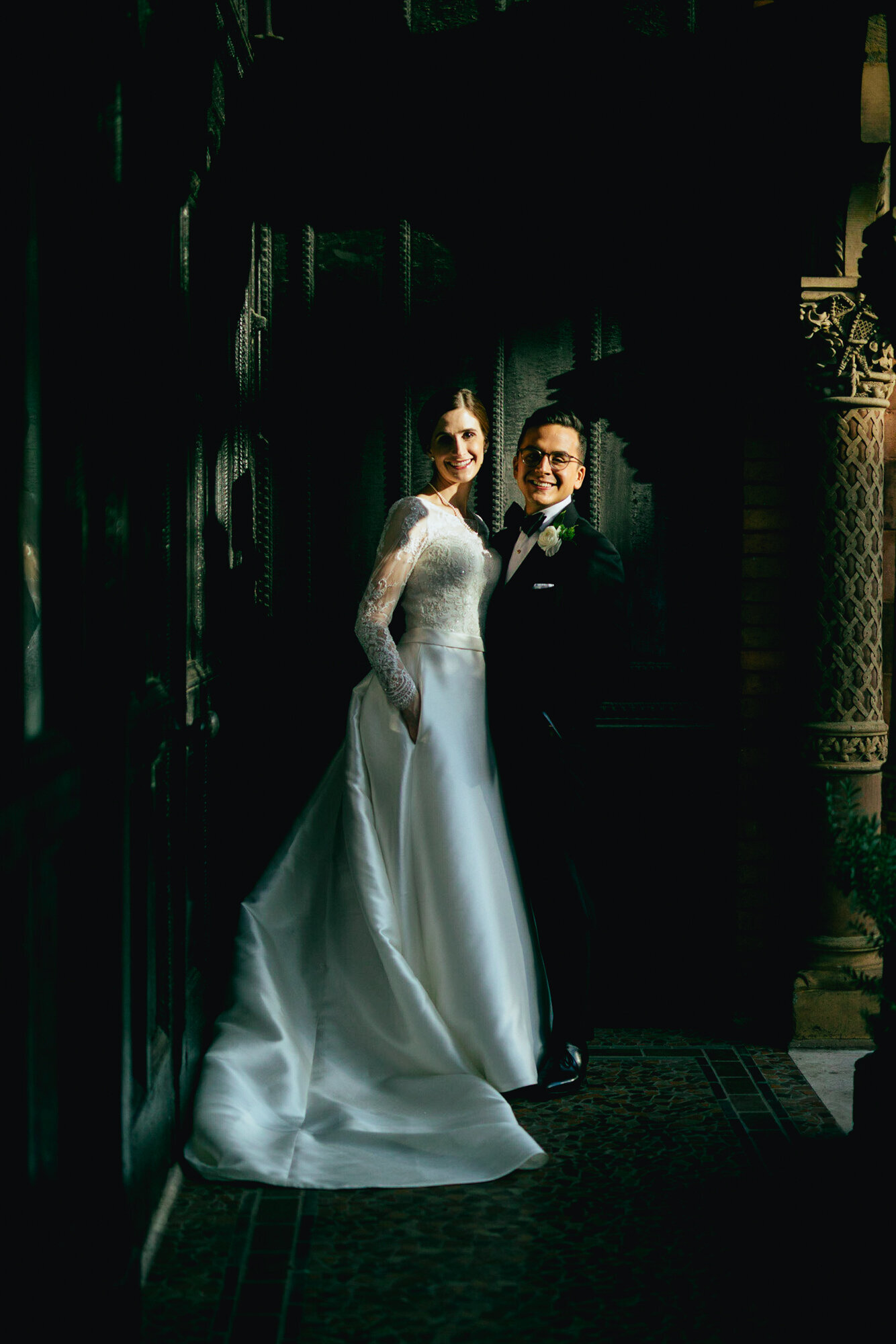 Bride and groom posing together in dramatic lighting in RVA Shawnee Custalow Queer Wedding Photographer