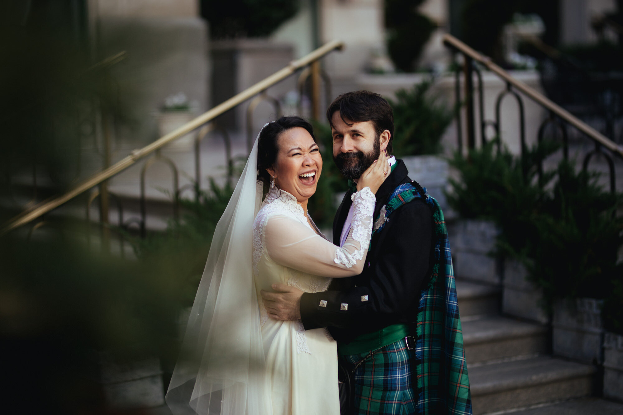 Bride and groom in a kilt smiling and embracing in RVA Shawnee Custalow Queer Wedding Photographer