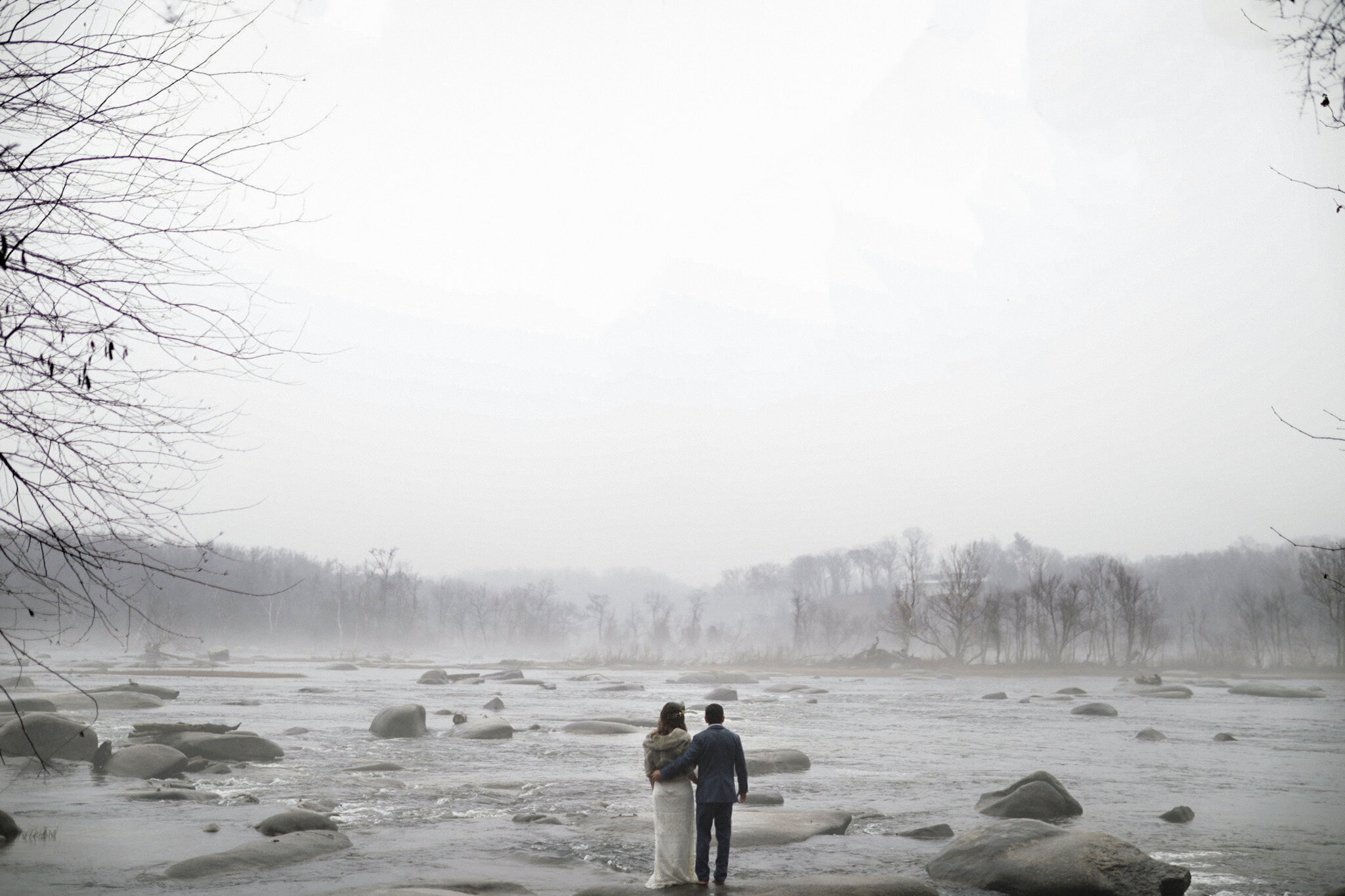 Bride and groom looking out over a misty James River landscape in Virginia Shawnee Custalow Queer Wedding Photographer