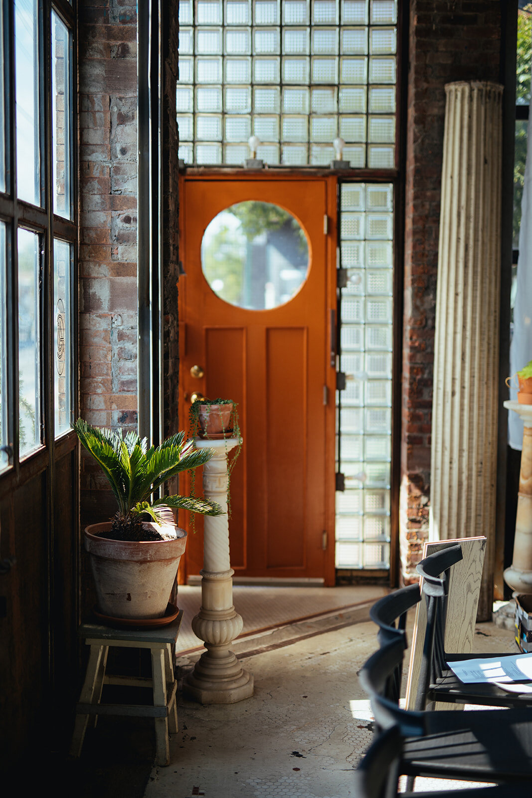 Sunlit hallway with orange door before wedding at Marlow Events Red Hook Brooklyn Shawnee Custalow Queer Wedding Photographer