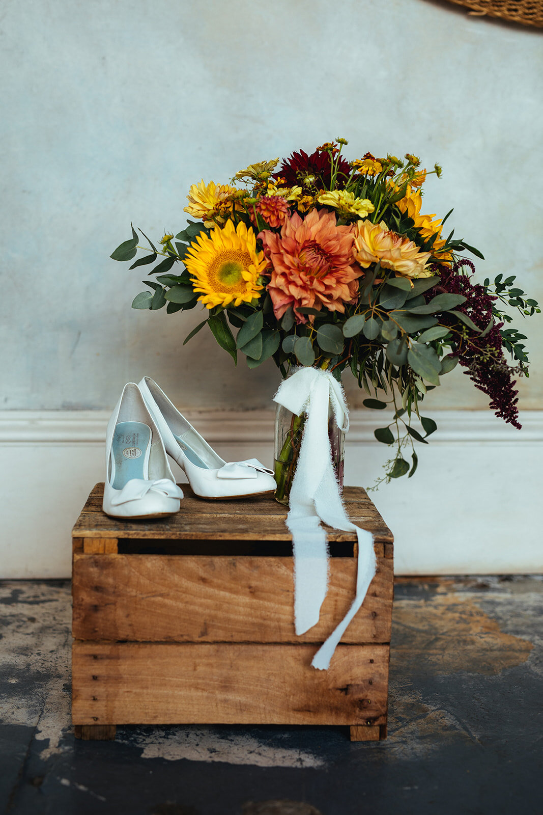 Orange and yellow bouquet with wide heeled shoes in Red Hook Brooklyn Shawnee Custalow Queer Wedding Photographer
