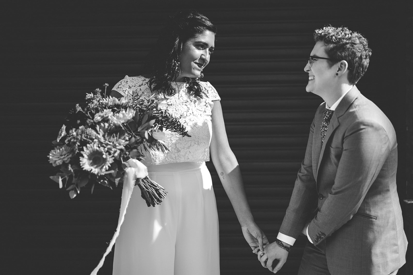 Queer couple in wedding attire holding hands in Red Hook Brooklyn Shawnee Custalow Queer Wedding Photographer