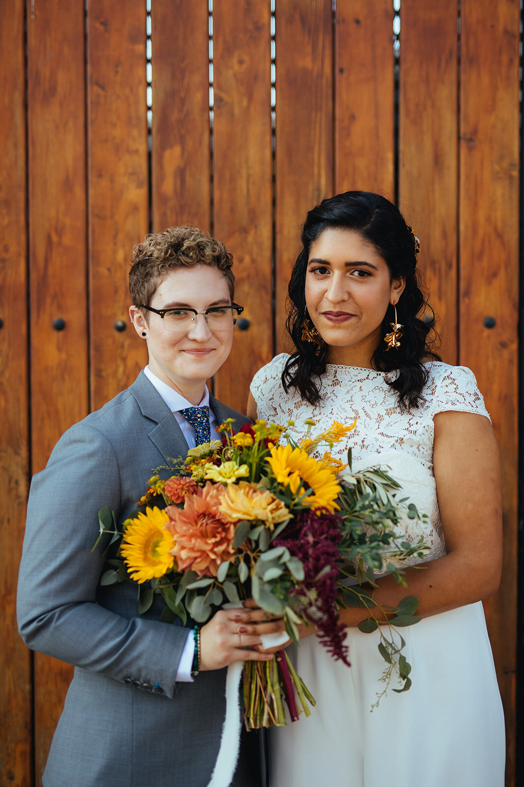 LGBTQ holding a yellow and orange bouquet before wedding in Brooklyn Shawnee Custalow